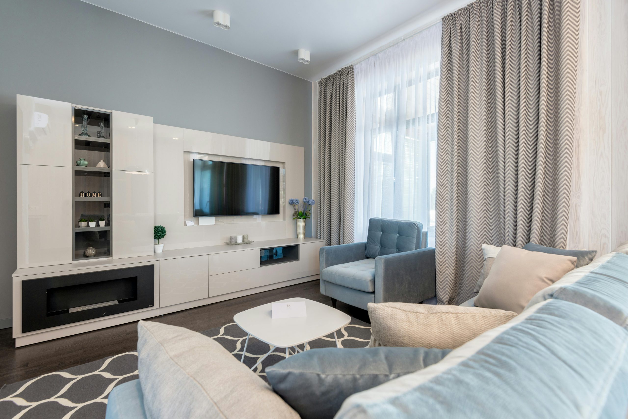 Stylish contemporary living room interior with modern furniture and blue accents.