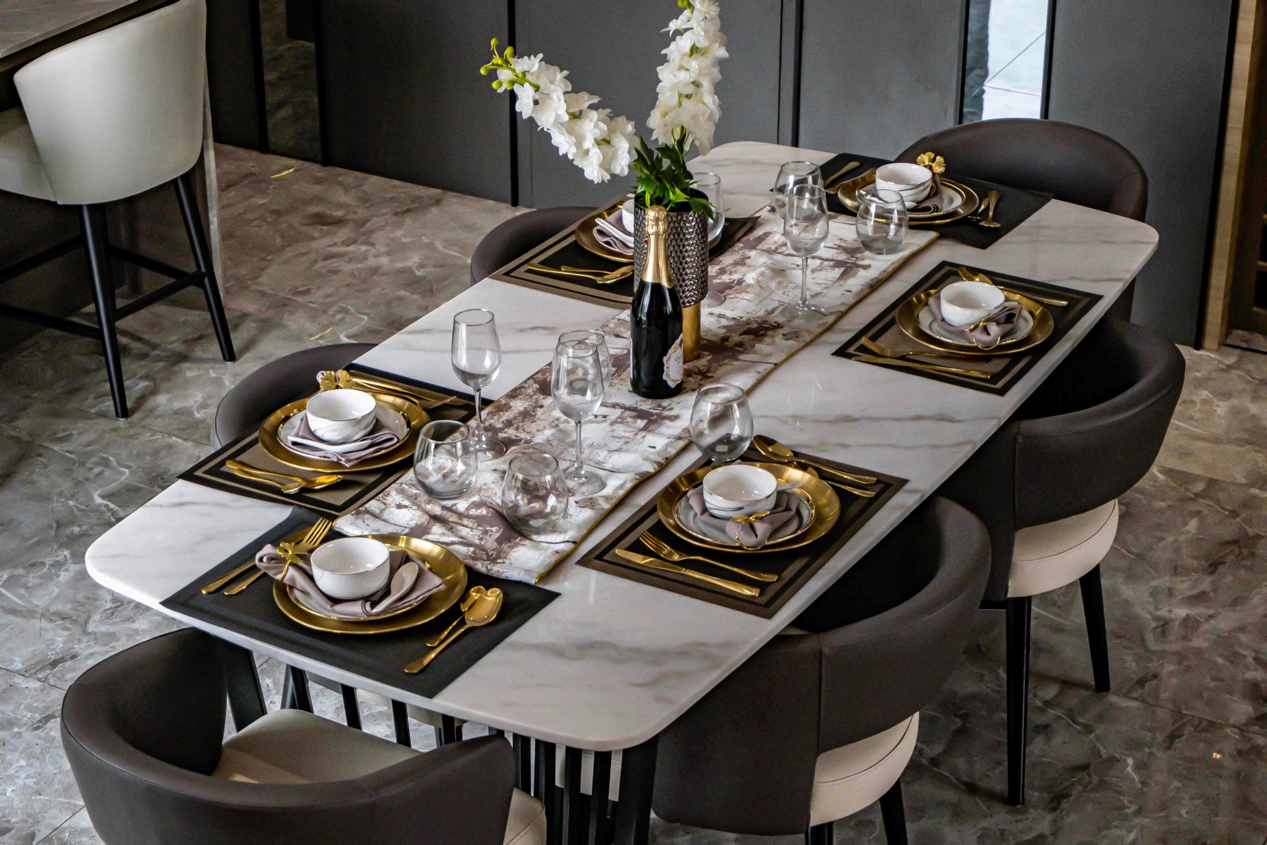 Stylish dining table setup in a modern space with elegant decor and tableware.