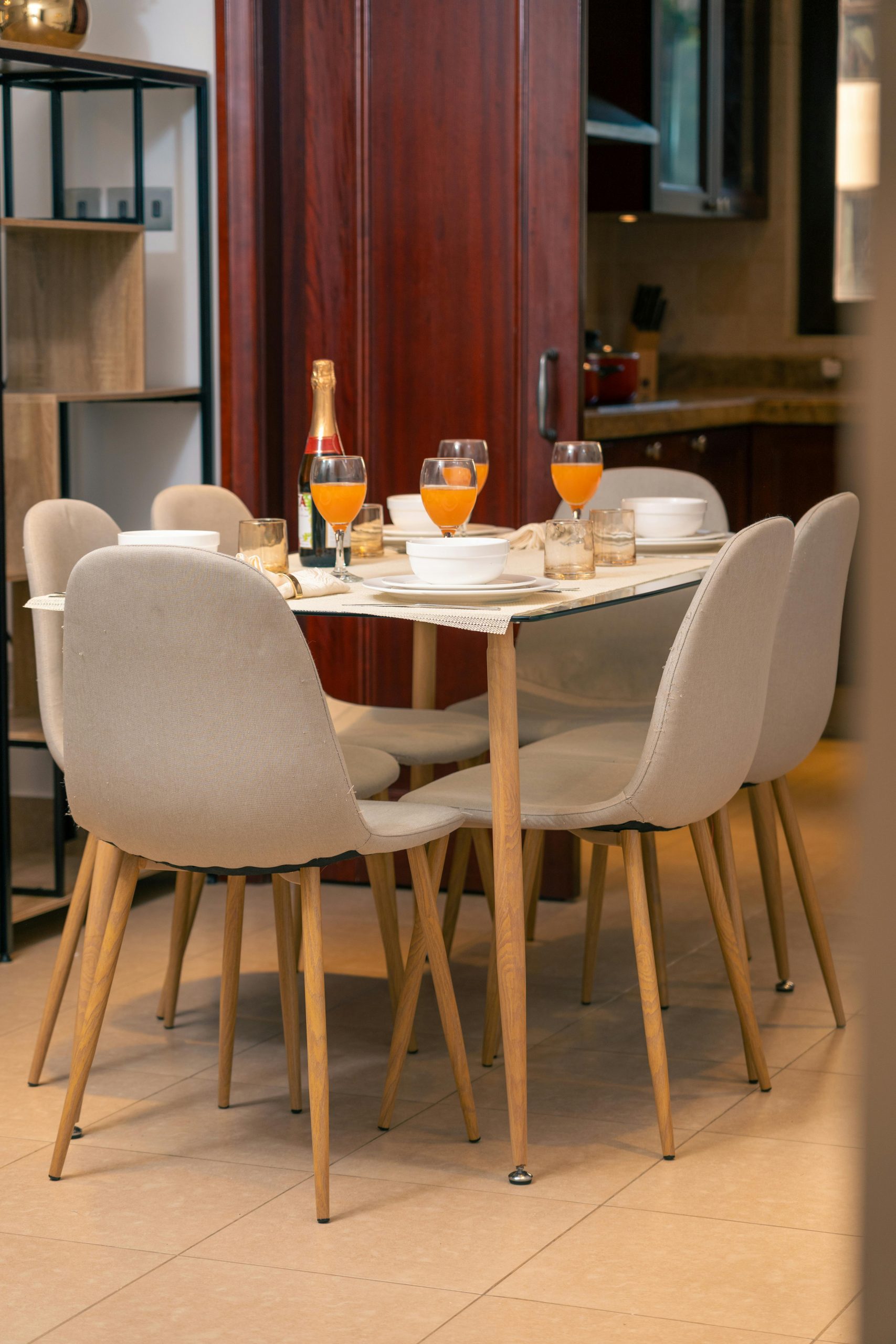 Stylish dining table with glasses of orange juice in a contemporary kitchen setting.