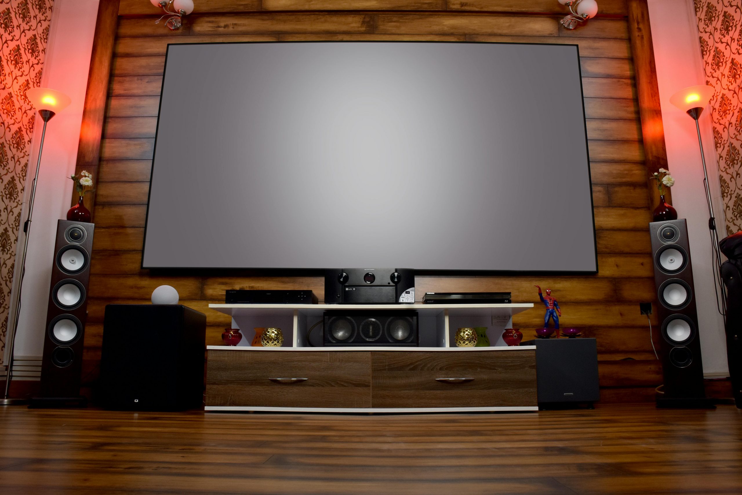 Stylish home theater featuring large screen, audio system, and decor, perfect for entertainment.