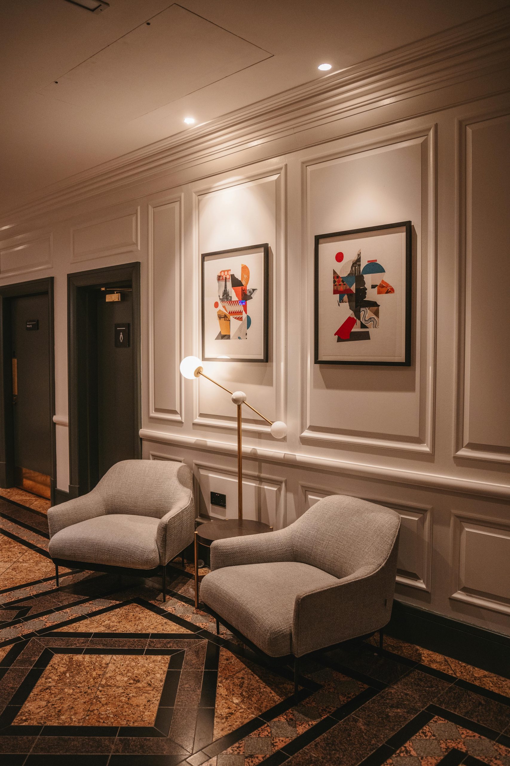 Stylish hotel lounge featuring modern abstract art and cozy armchairs in a serene setting.
