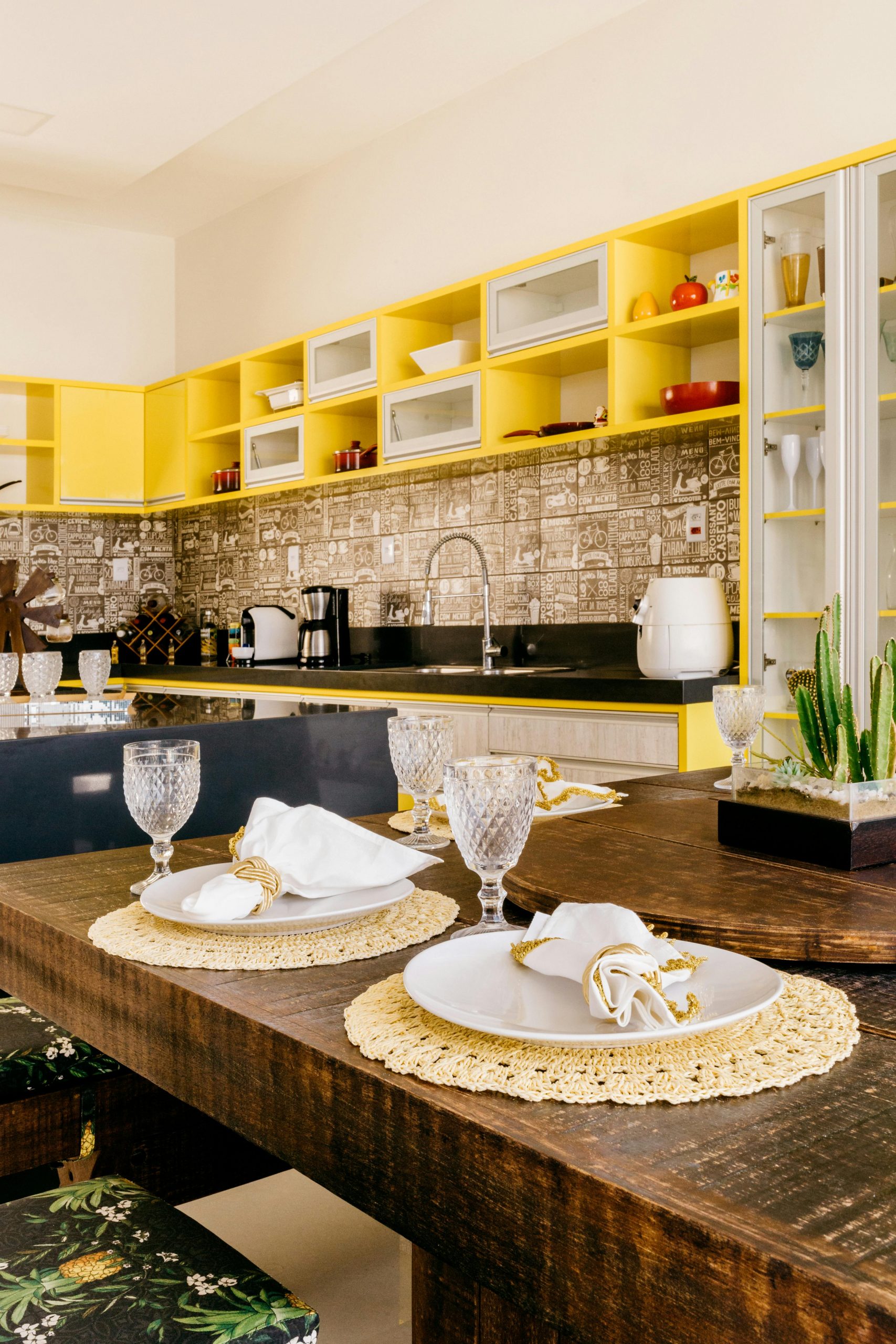 Stylish kitchen interior featuring vibrant yellow shelving and a rustic dining table.