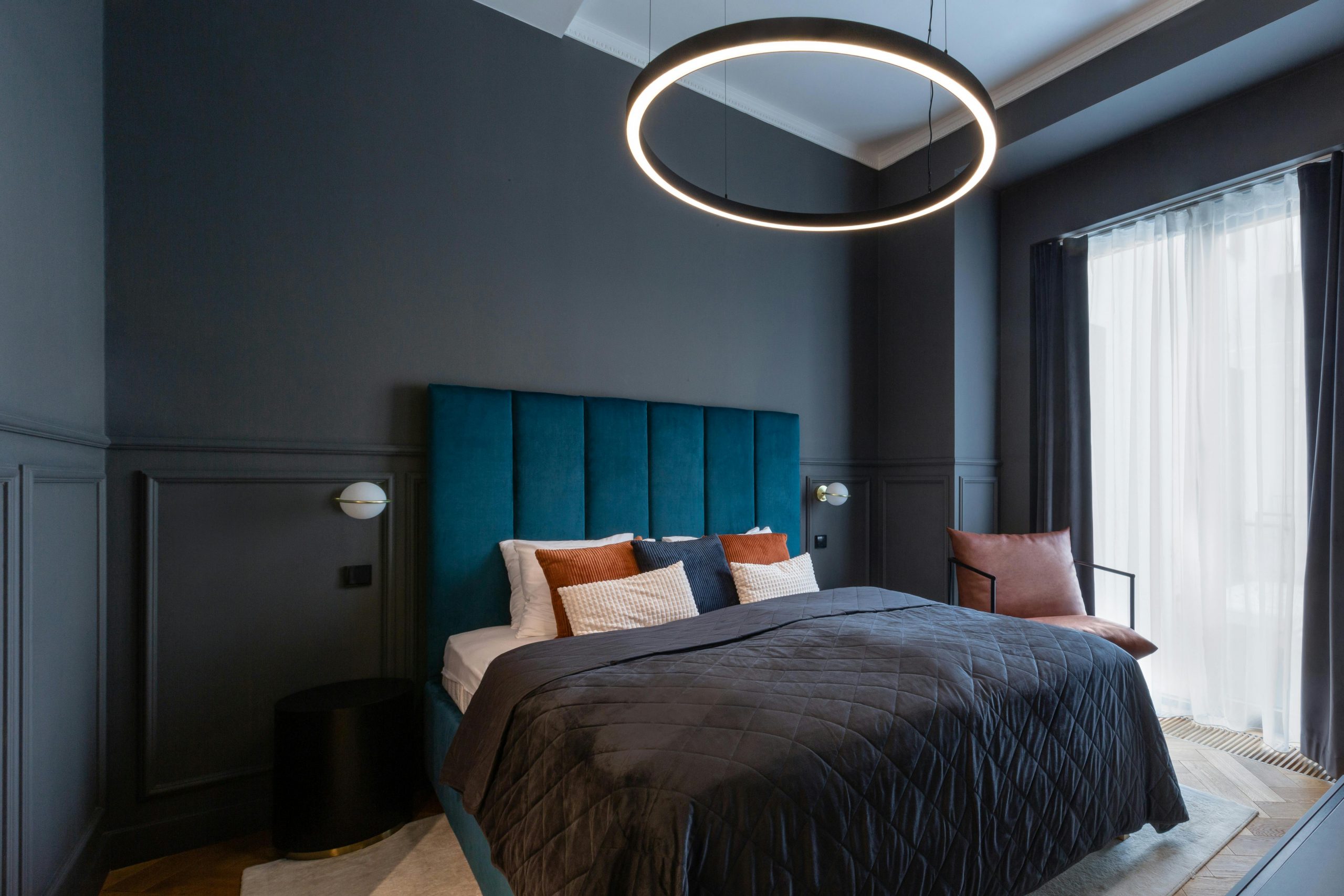 Stylish modern bedroom in Prague featuring a contemporary ring light and cozy bedding.