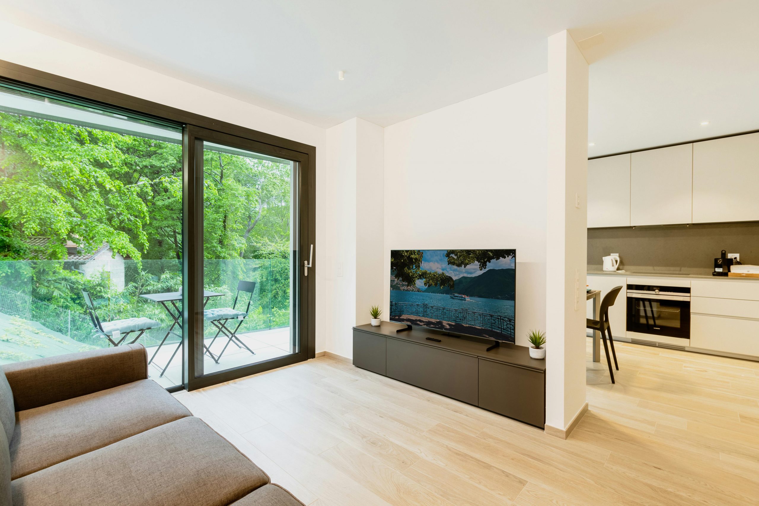 Stylish open-plan apartment featuring minimalist design and greenery view.