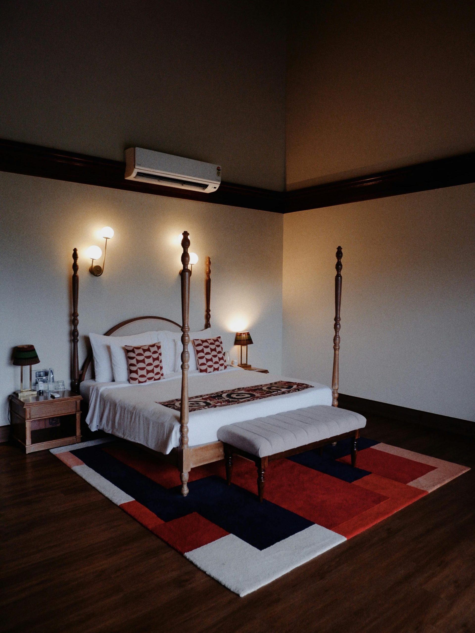 Warmly lit bedroom with four-poster bed and stylish decor for a cozy atmosphere.