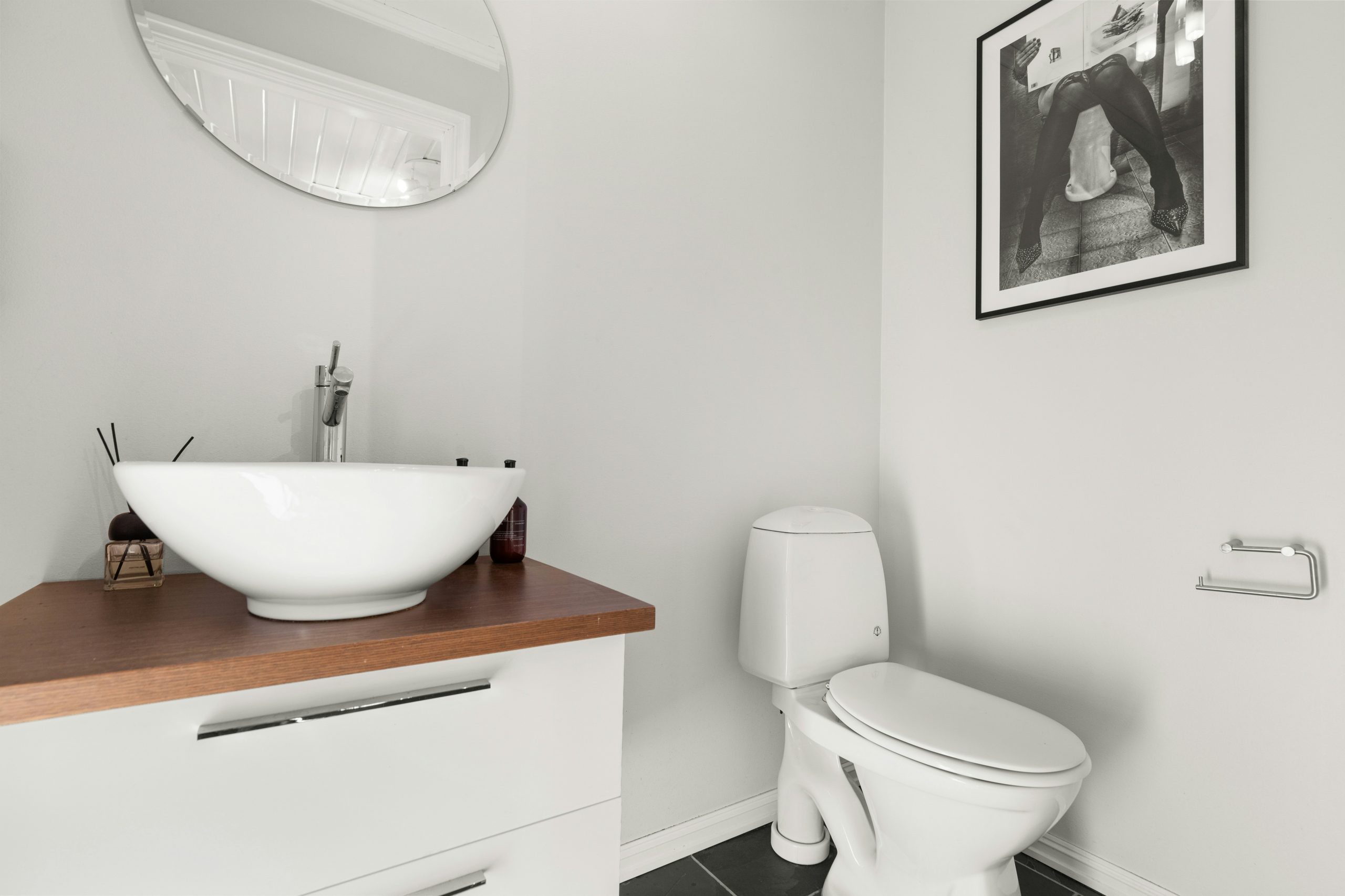 A bathroom with a sink, toilet and mirror
