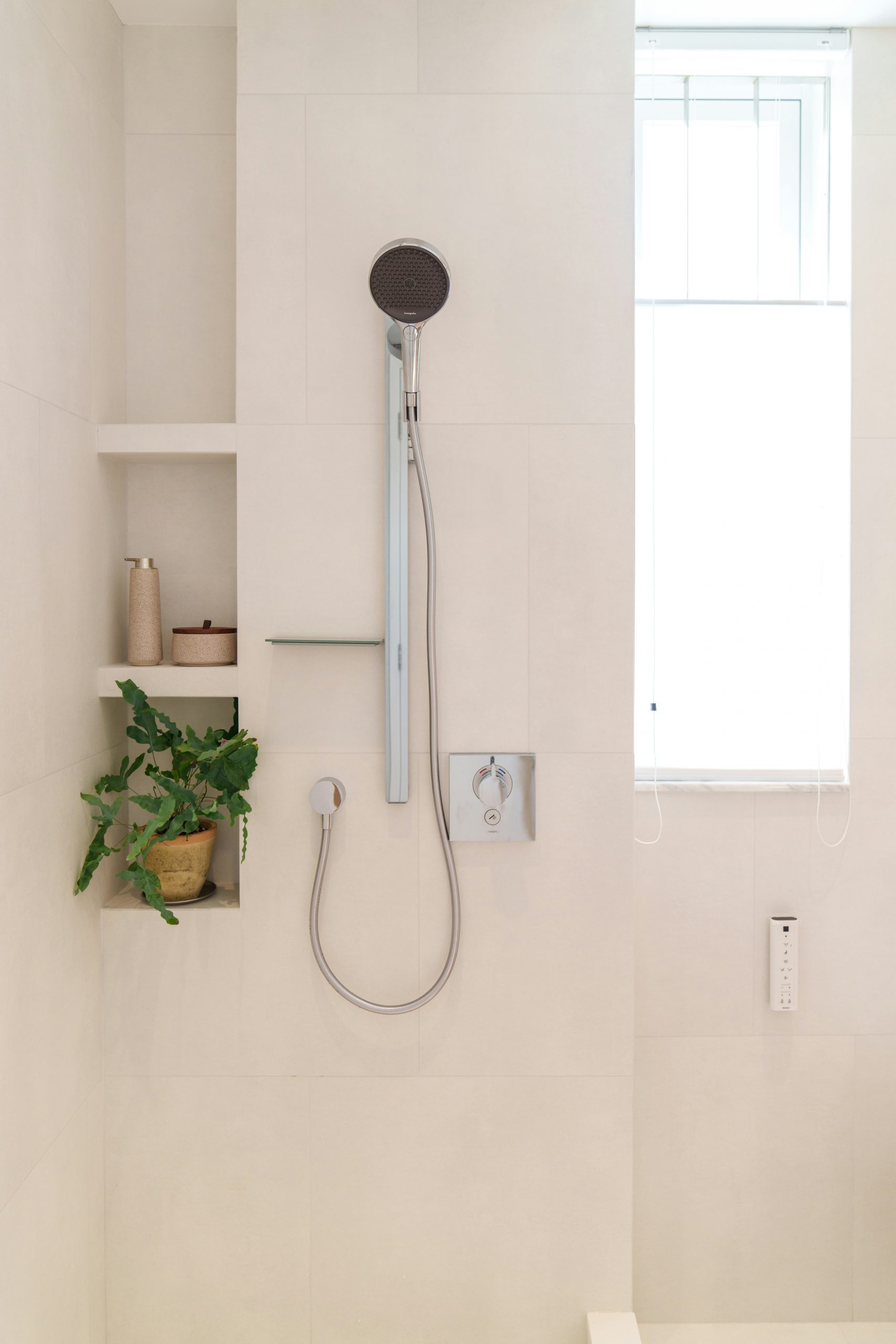A bathroom with a toilet and a shower head