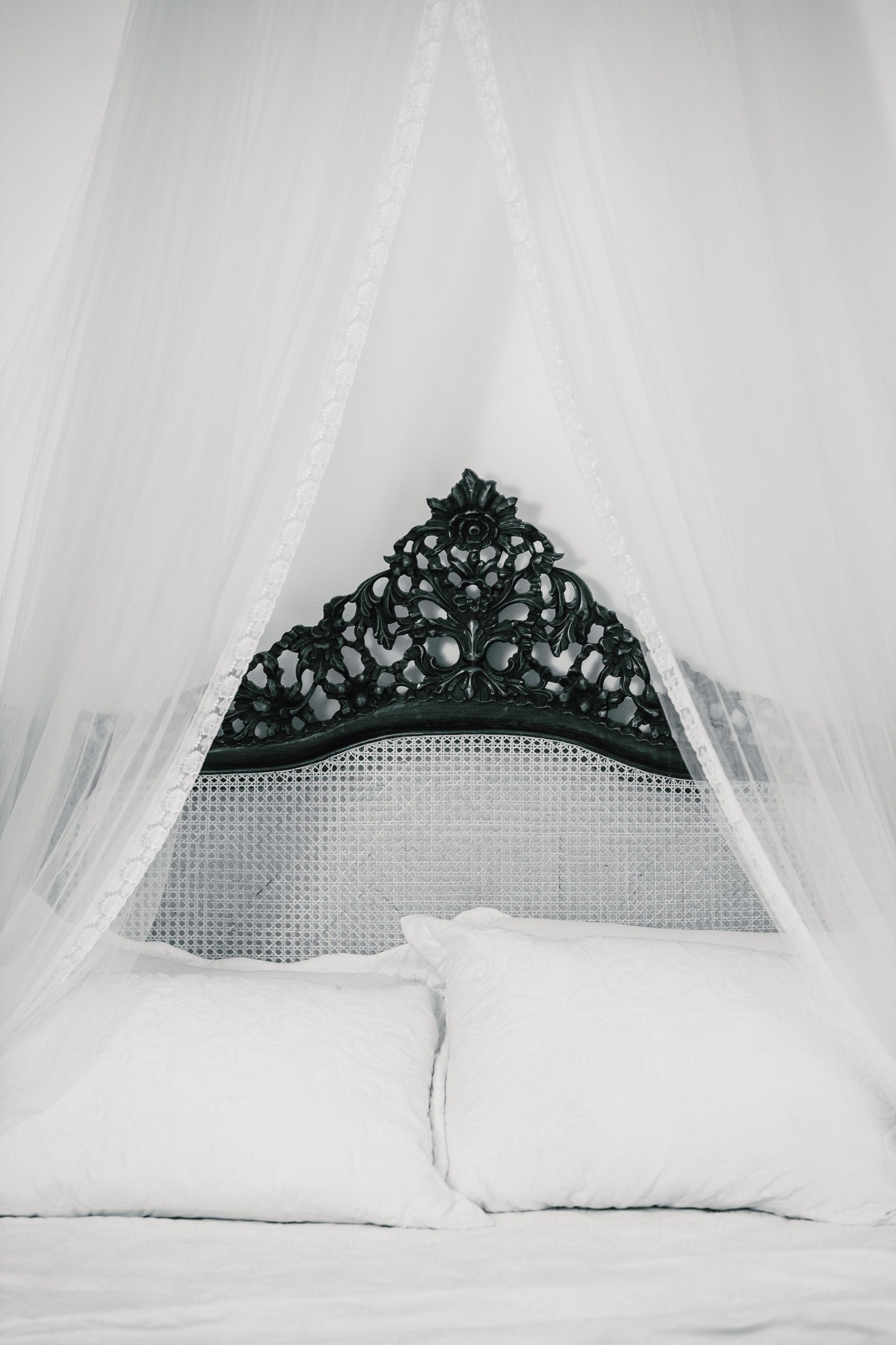 A beautifully crafted vintage bed with an ornate canopy, exuding elegance and charm.