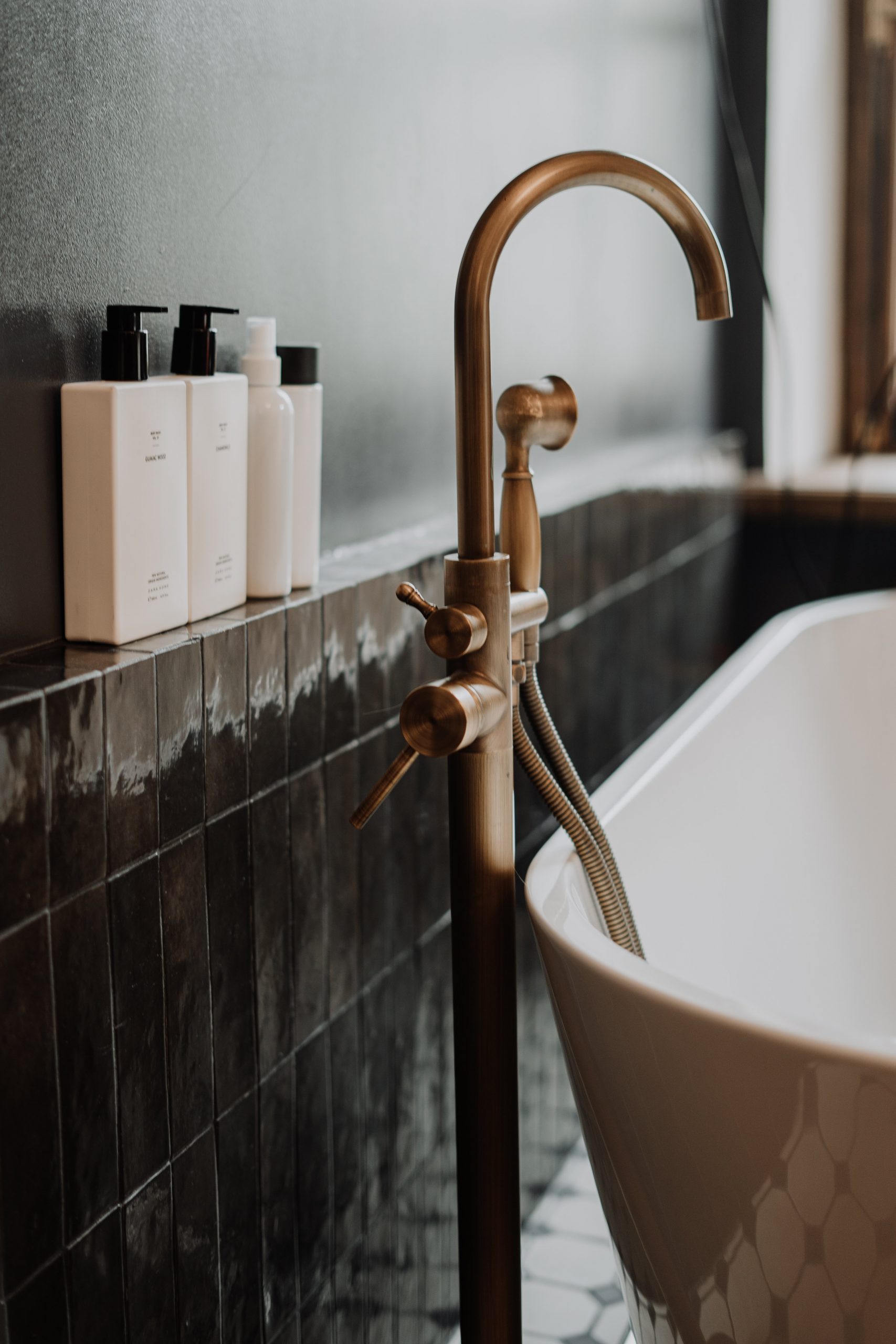 A modern bathroom with gold fixtures and minimalist soap bottles enhancing its elegant appeal.