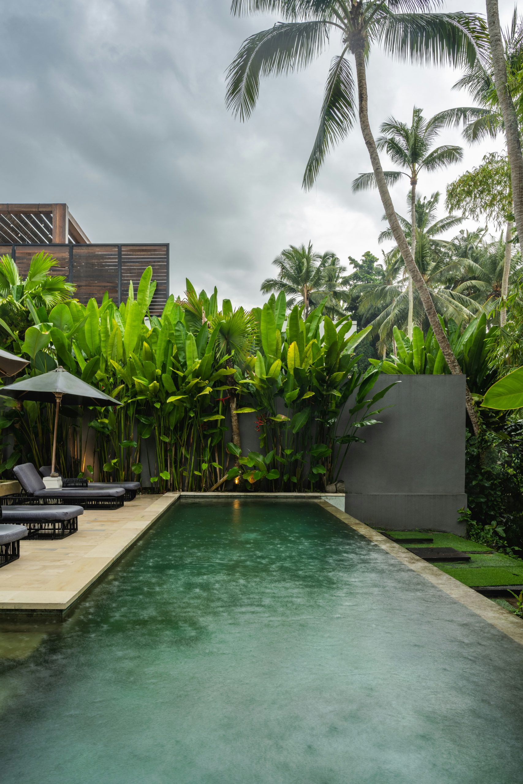 A pool with lounge chairs and umbrellas next to it
