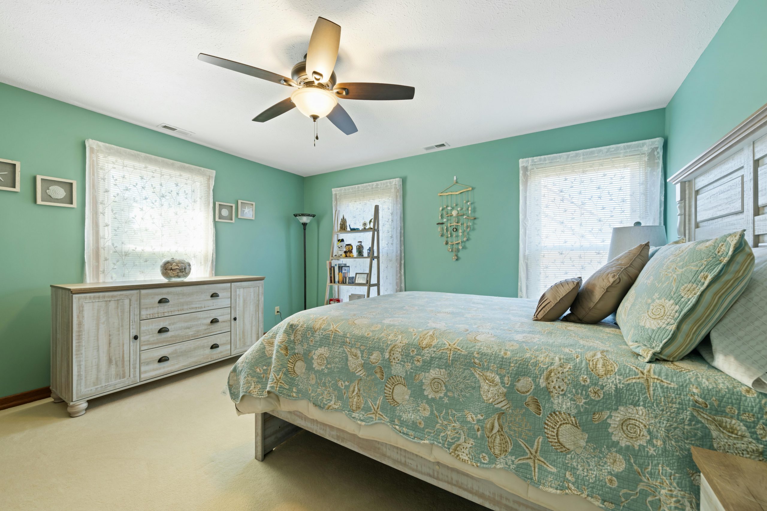 A serene aqua-themed bedroom featuring coastal decor and wooden furniture.