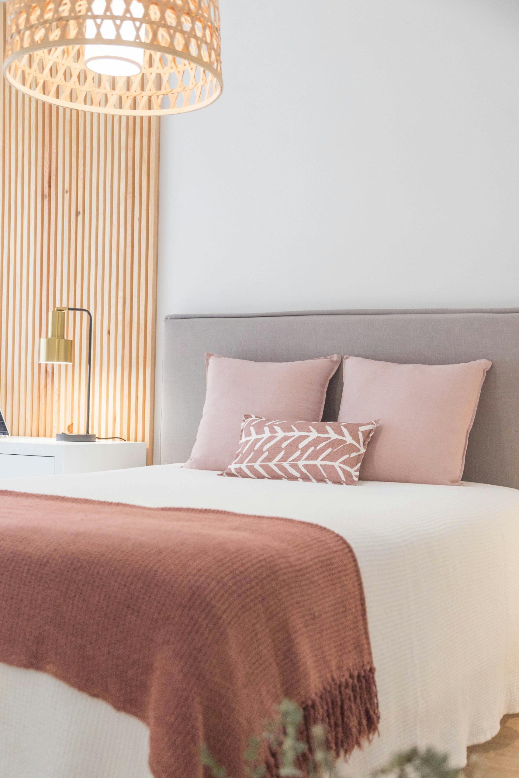 A serene minimalist bedroom featuring soft tones with elegant decor and cozy textiles.