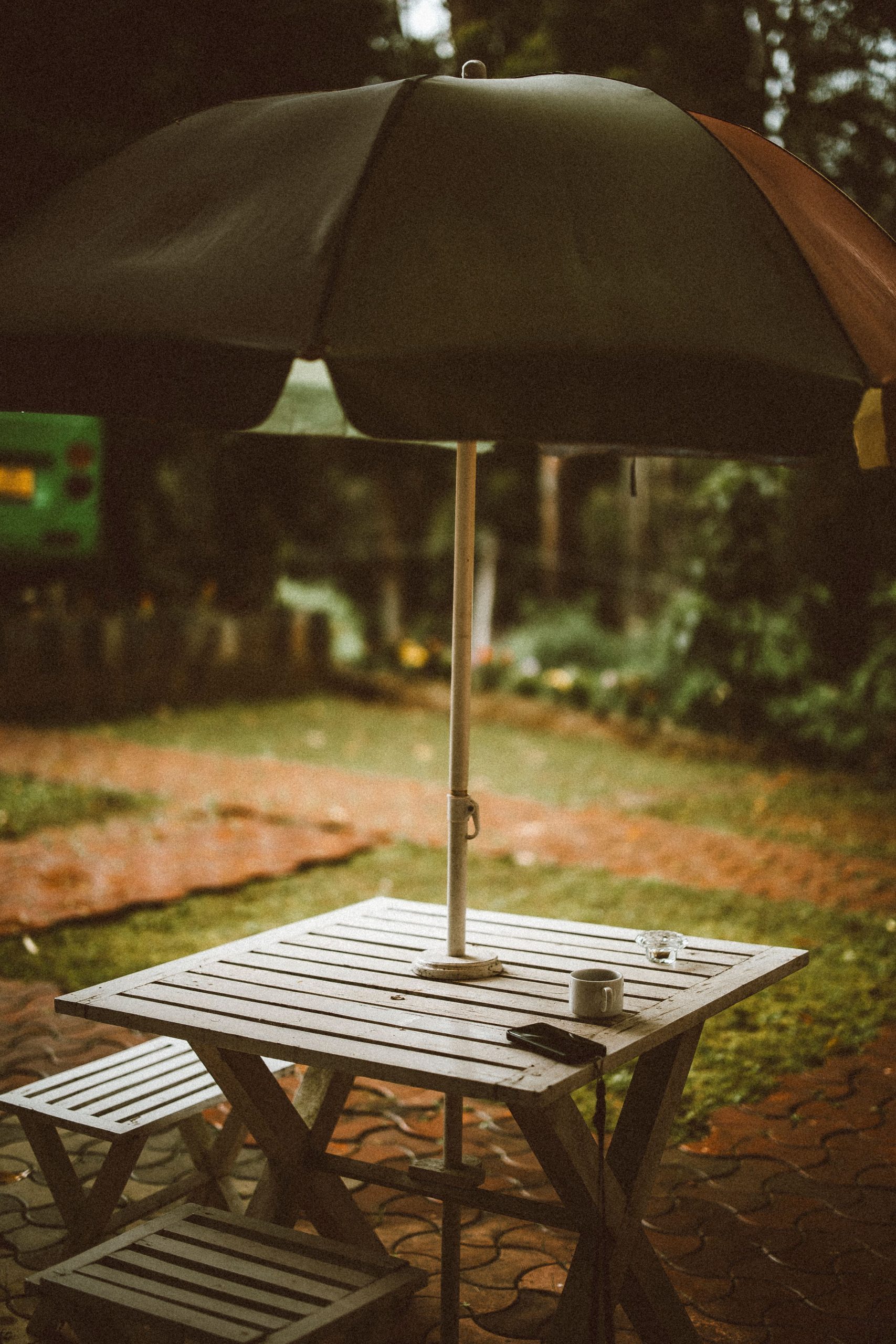 A serene outdoor setting with a table, chairs, and umbrella, offering a peaceful ambiance.