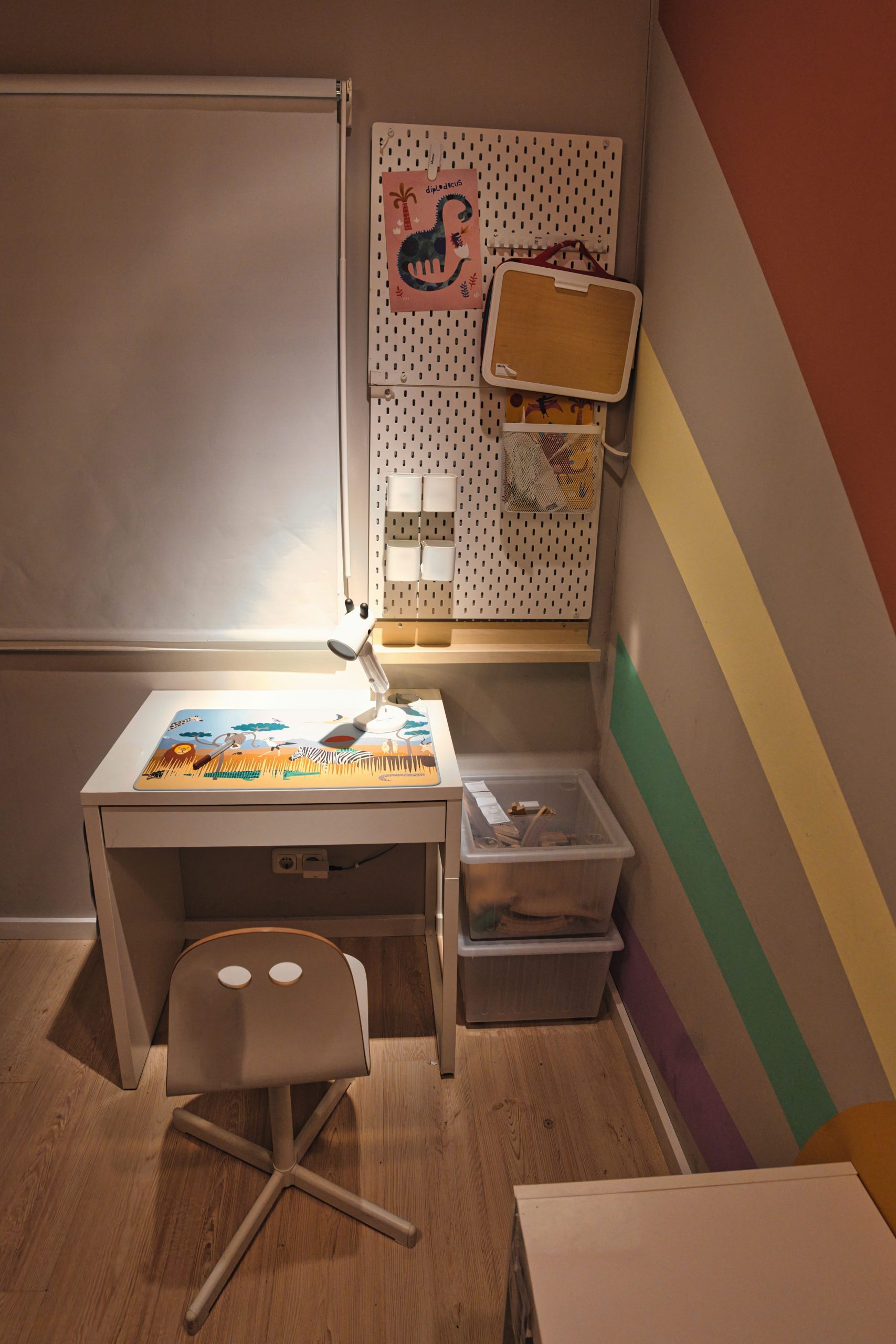 A well-lit children's study space with a small desk, colorful wall decor, and a chair, perfect for creativity.