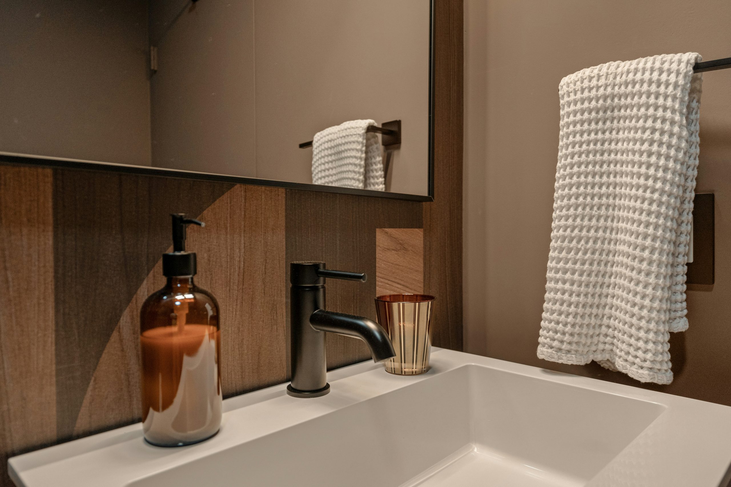 An elevated Palm Springs bathroom remodel blending natural stone, warm wood cabinetry, and spa-inspired lighting. Shot for an architectural designer to showcase luxury renovation details.