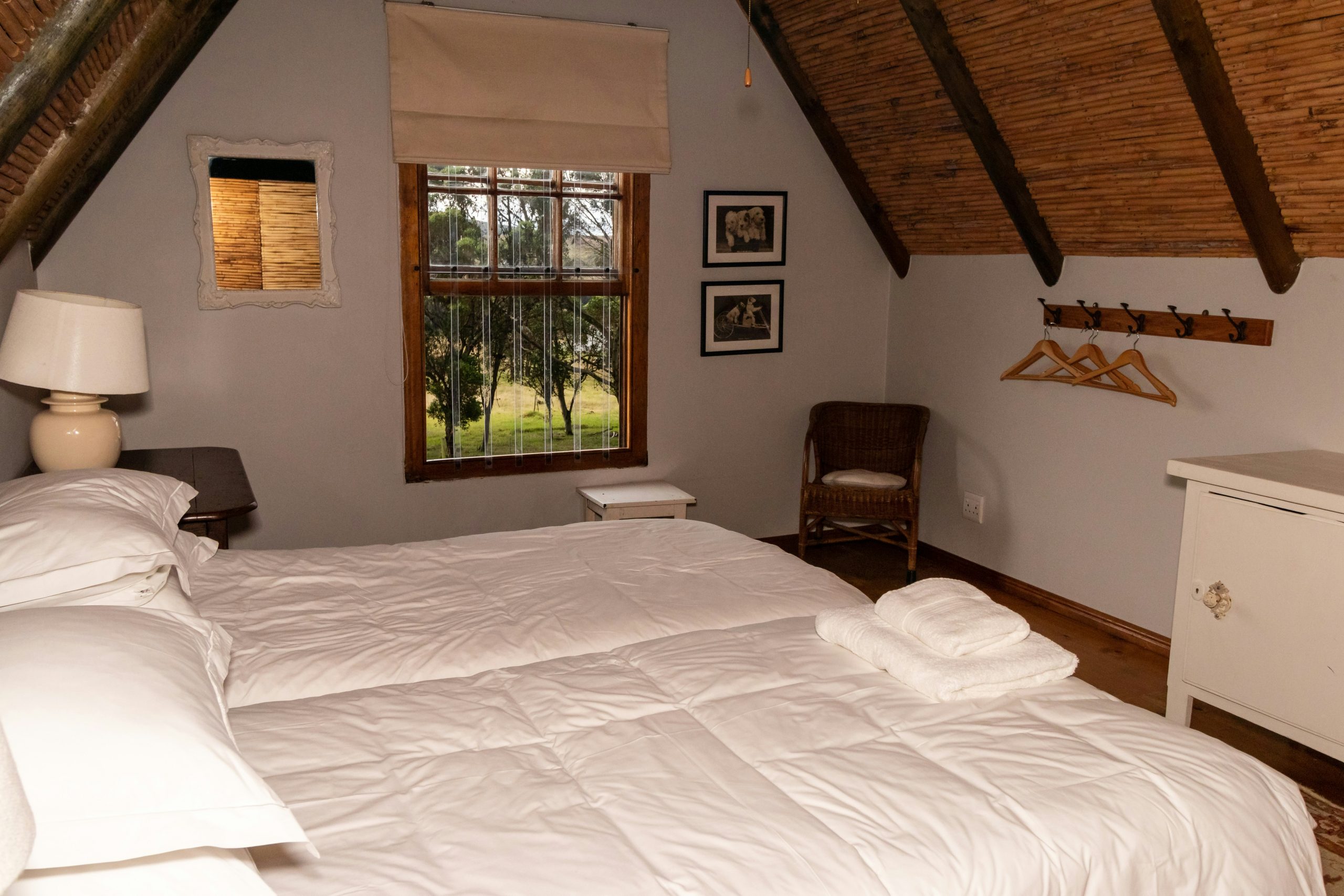 Bedroom in a farm cottage with a bedside lamp on a bedside table