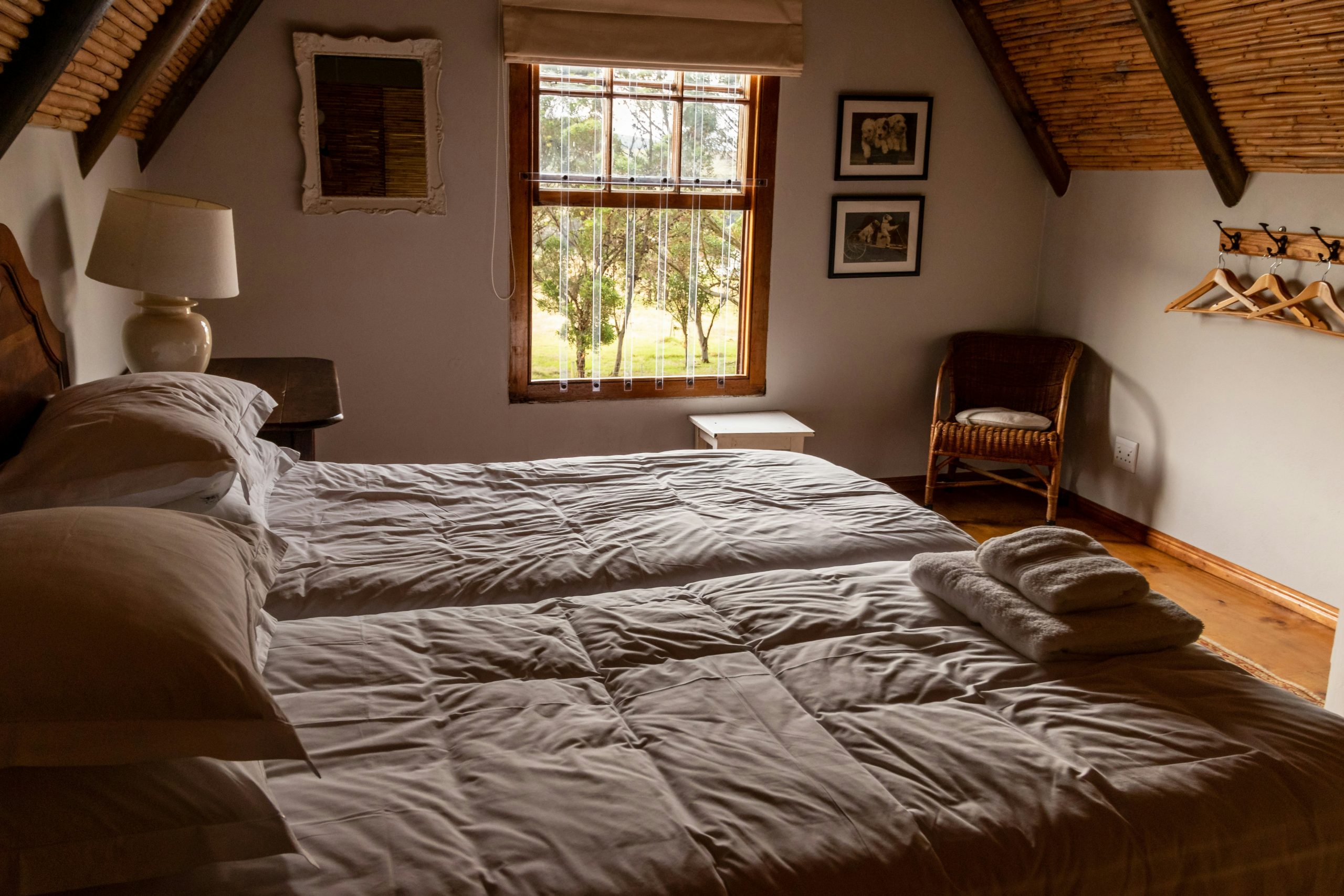 Bedroom in a farm cottage with a bedside lamp on a bedside table