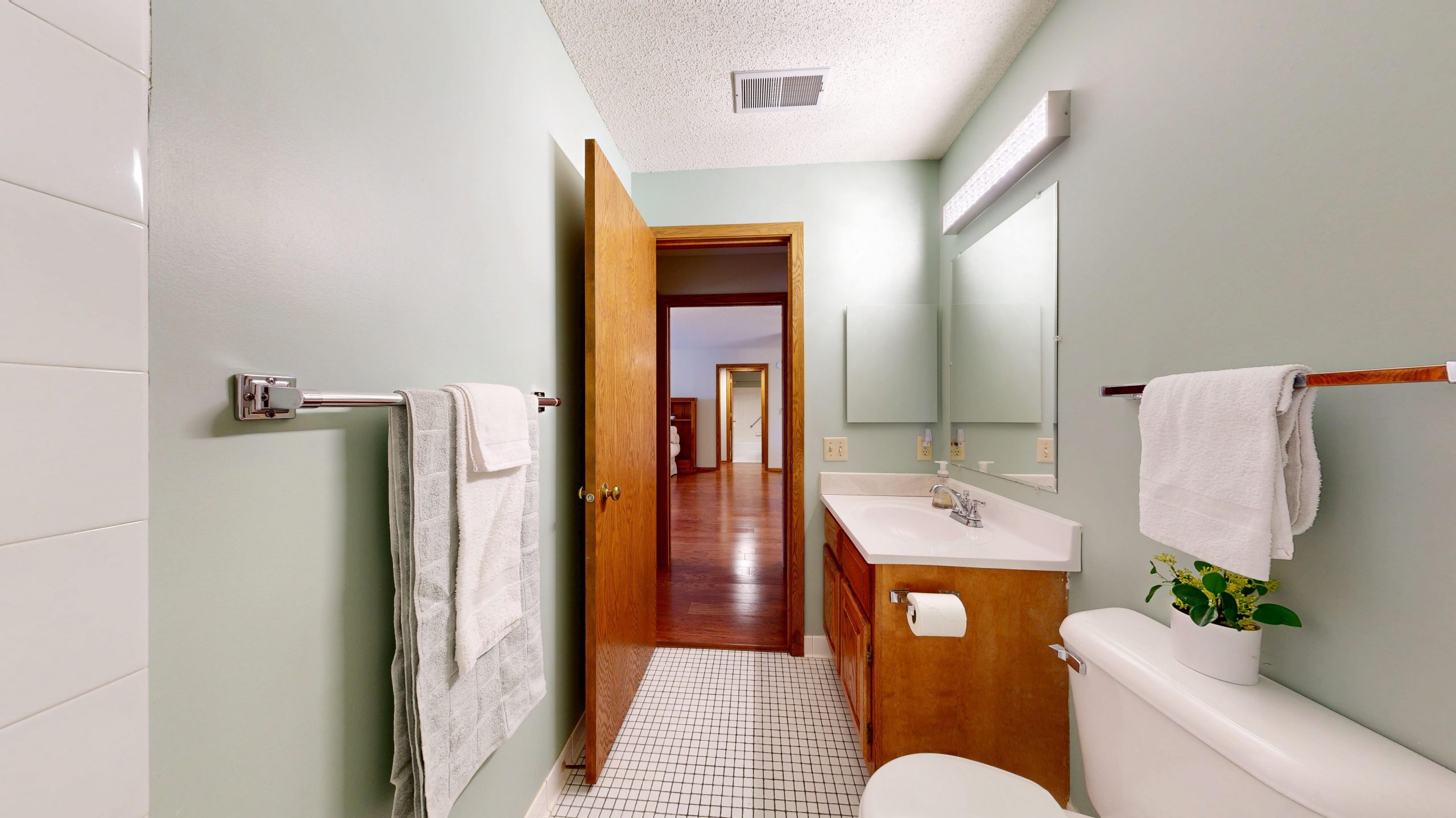 Bright bathroom featuring wooden cabinets and white towels for a clean, modern look.