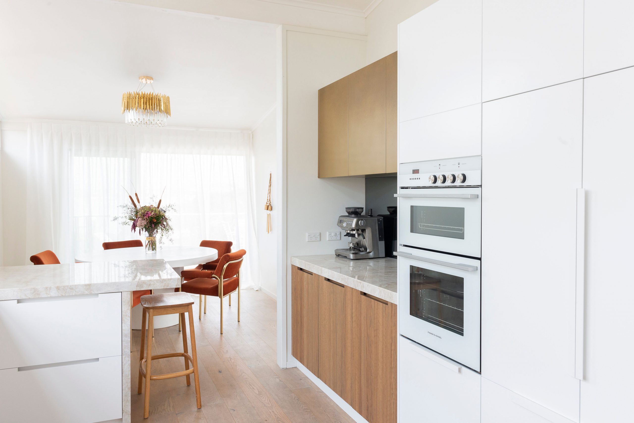 Bright kitchen interior with white cabinets and elegant decor, perfect for contemporary living.