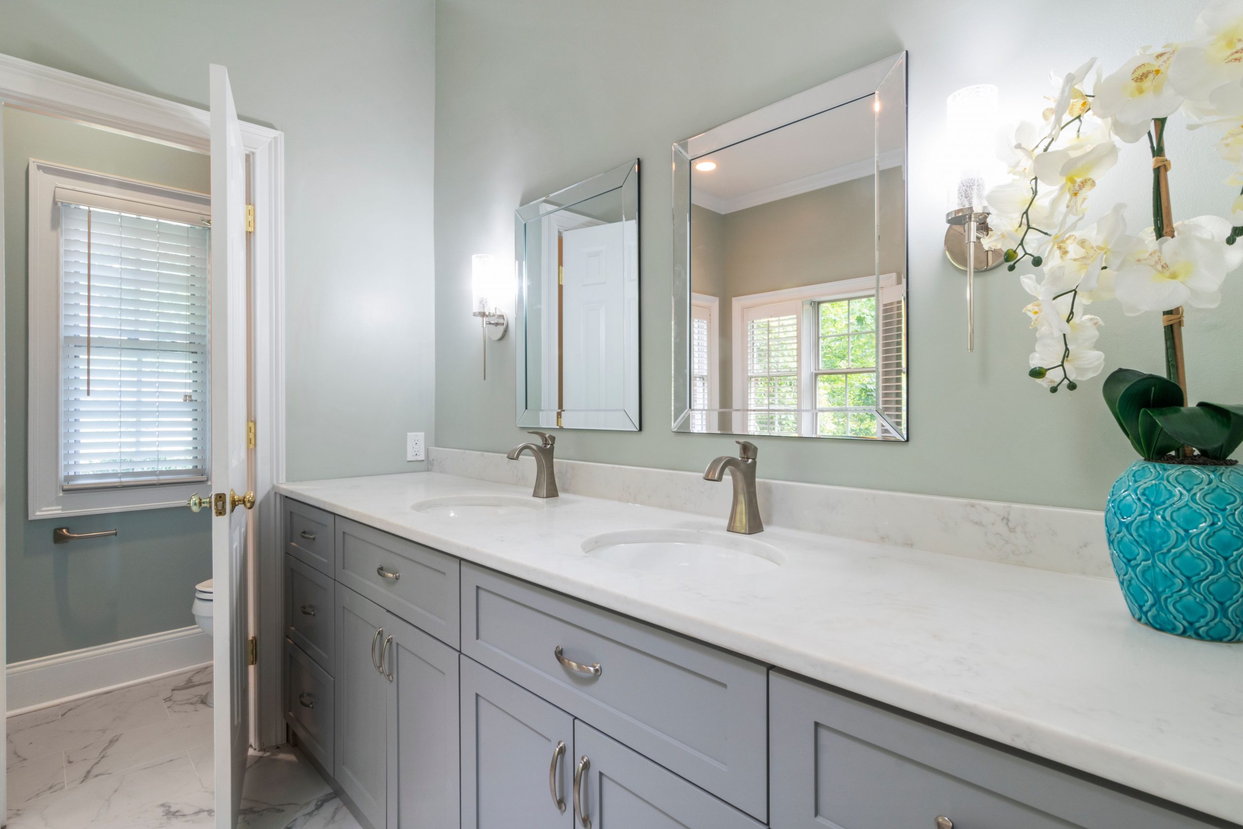 Bright modern bathroom featuring double vanity sinks, stylish mirrors, and a fresh, elegant design.
