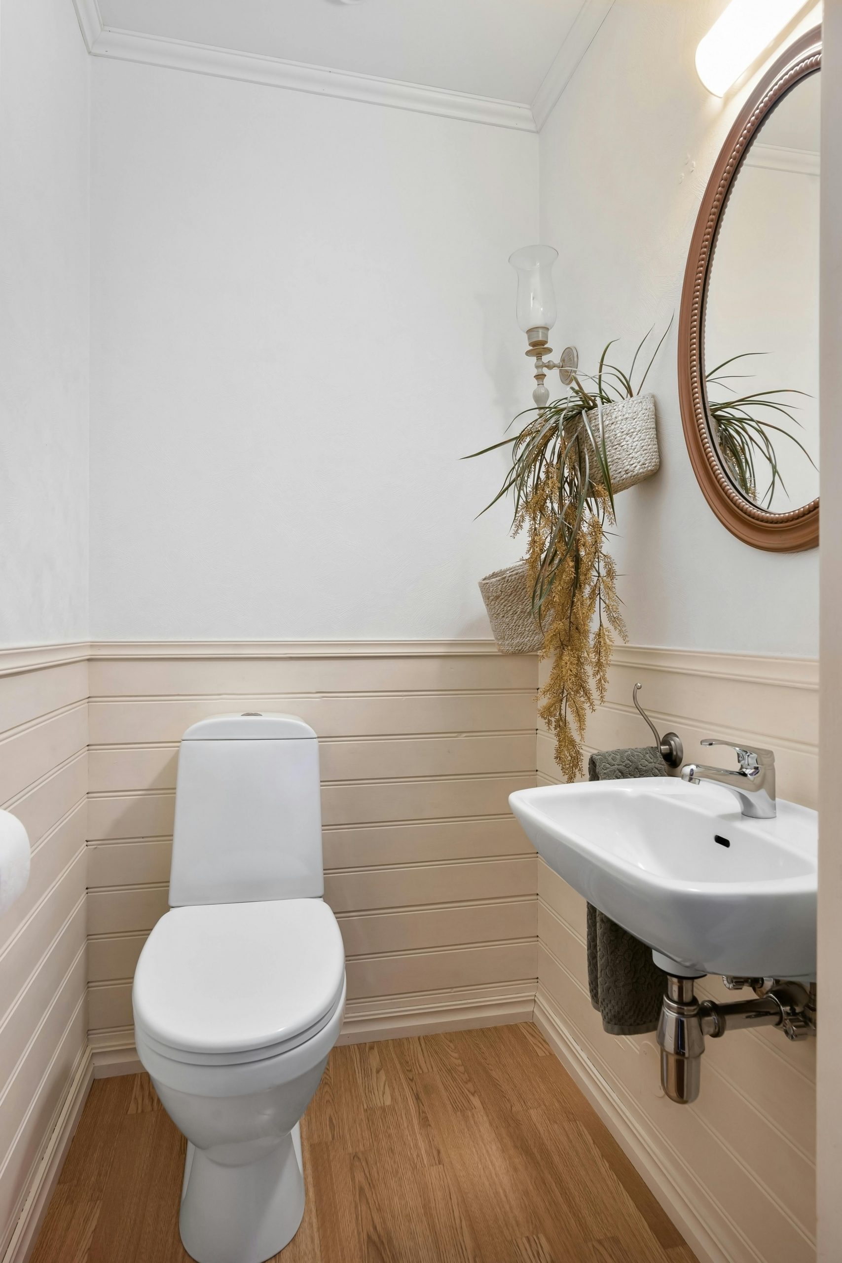 Chic minimalist bathroom featuring a modern white toilet and a stylish rectangular sink against a wooden floor.