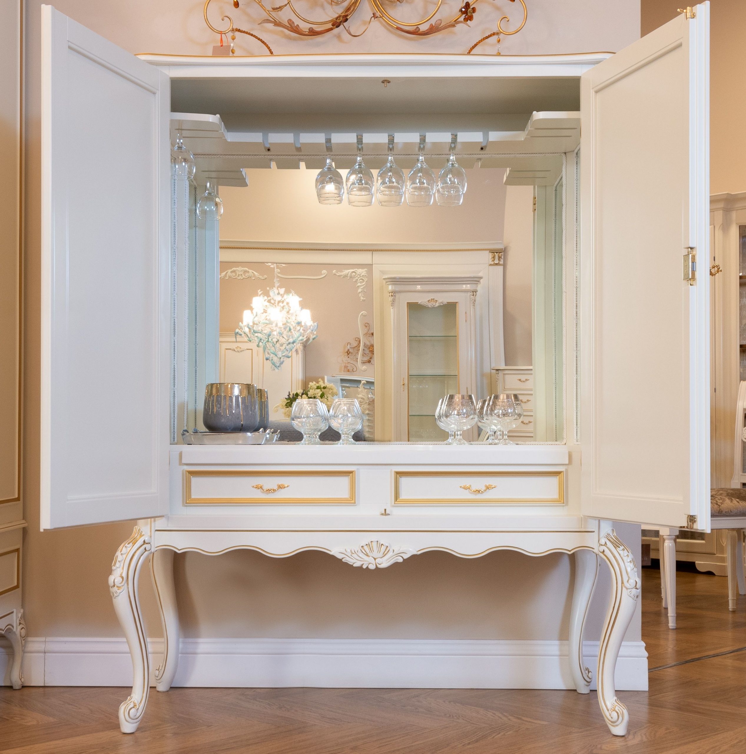 Chic vintage cabinet with open doors displaying glassware, perfect for elegant interior decor ideas.
