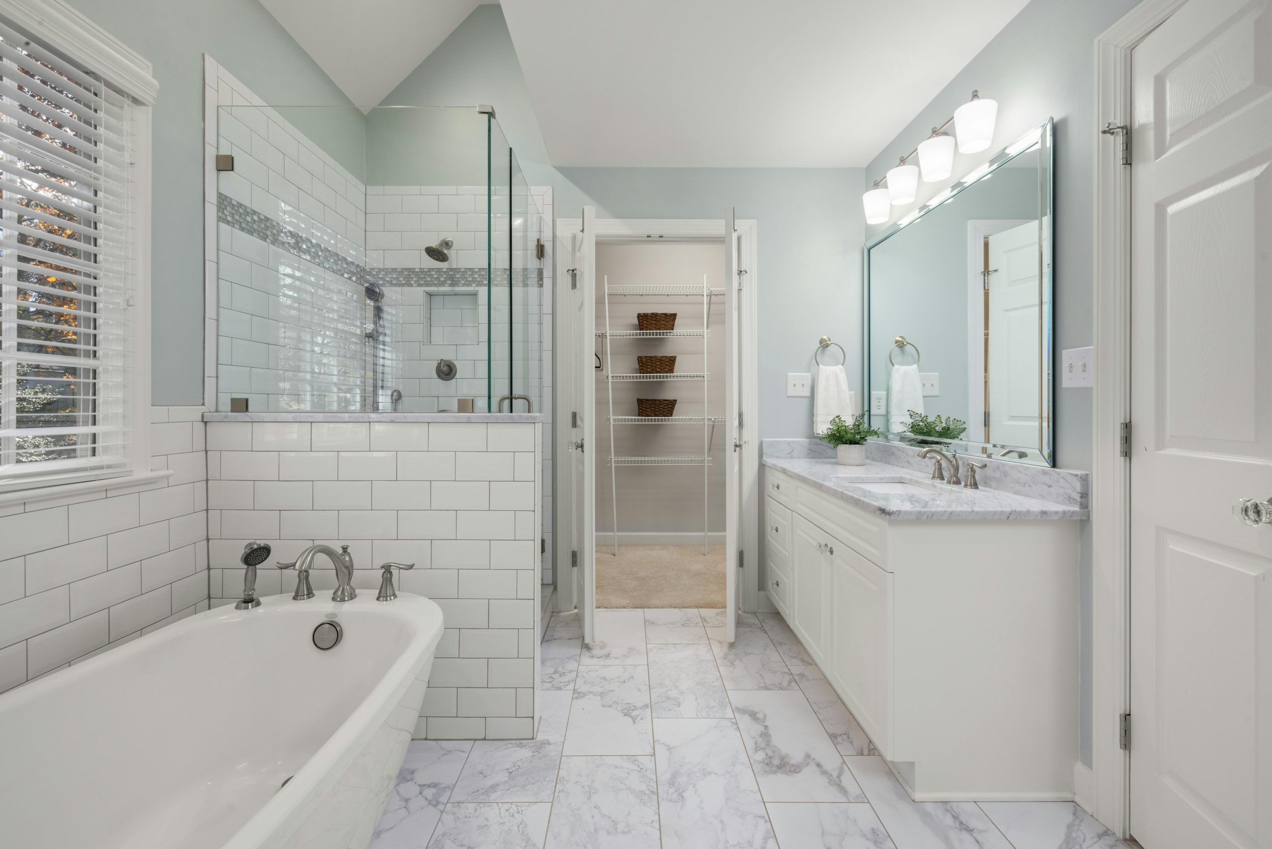 Elegant bathroom with white marble, glass shower, and bright lighting. Perfect for luxury home decor inspiration.