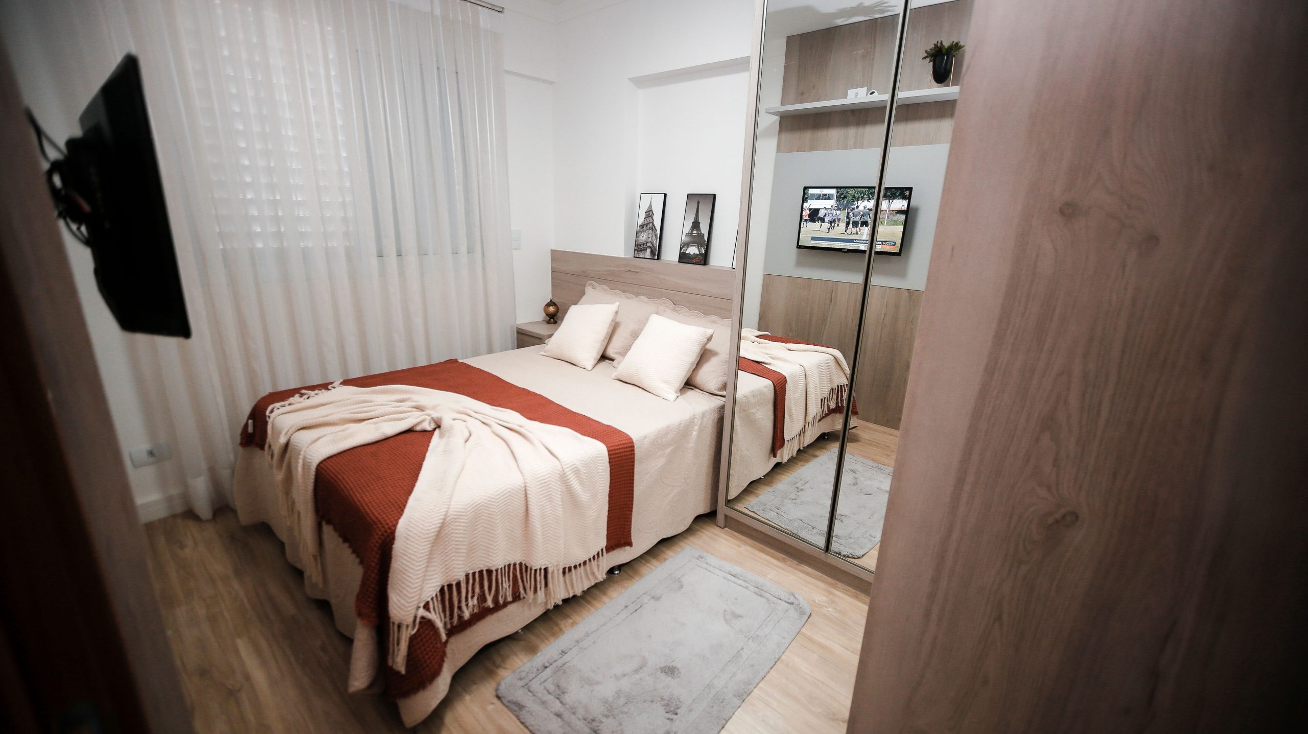 Elegant bedroom featuring a stylish double bed, mirror wardrobe, and cozy decor.