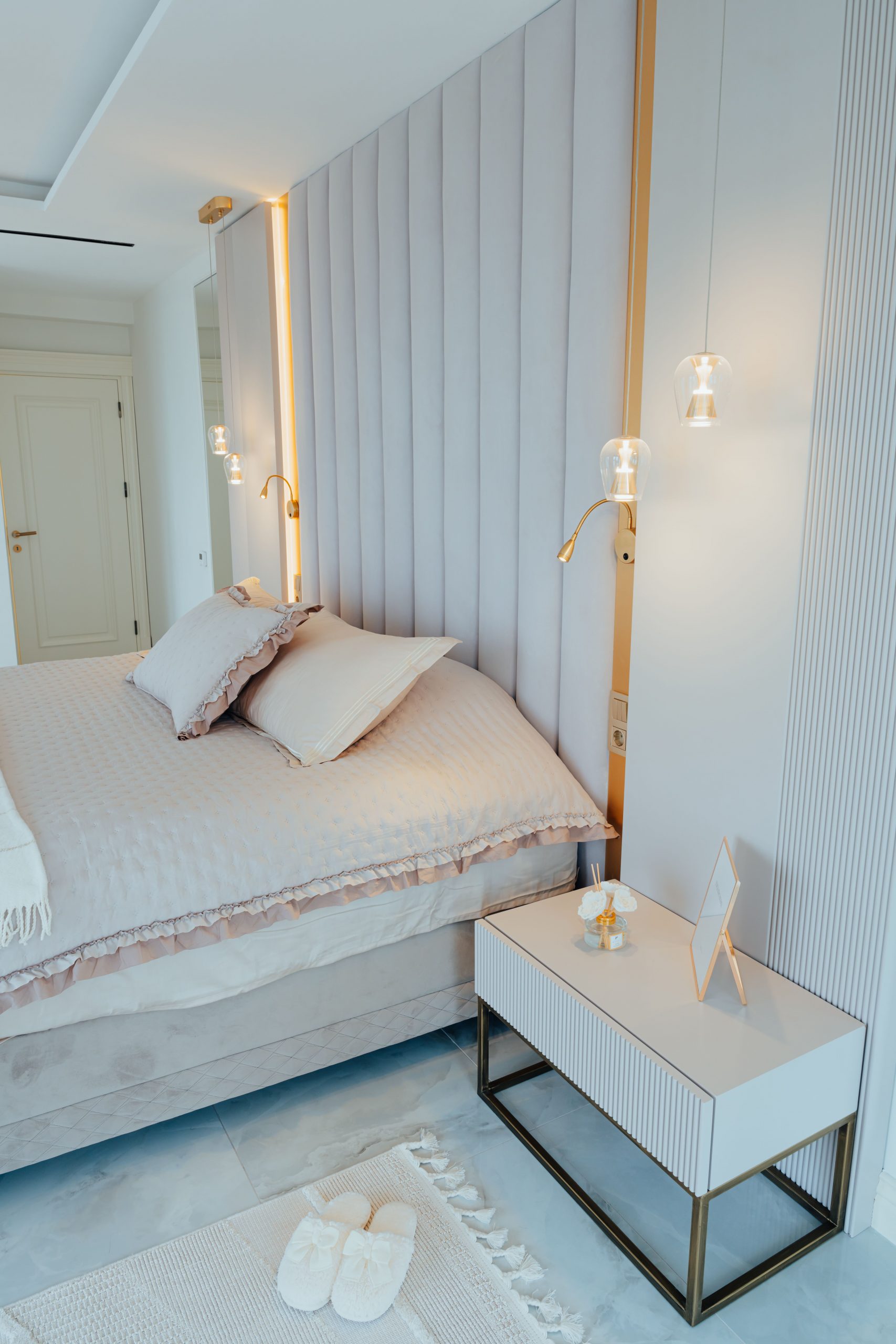 Elegant minimalist bedroom interior with plush bedding and ambient lighting.