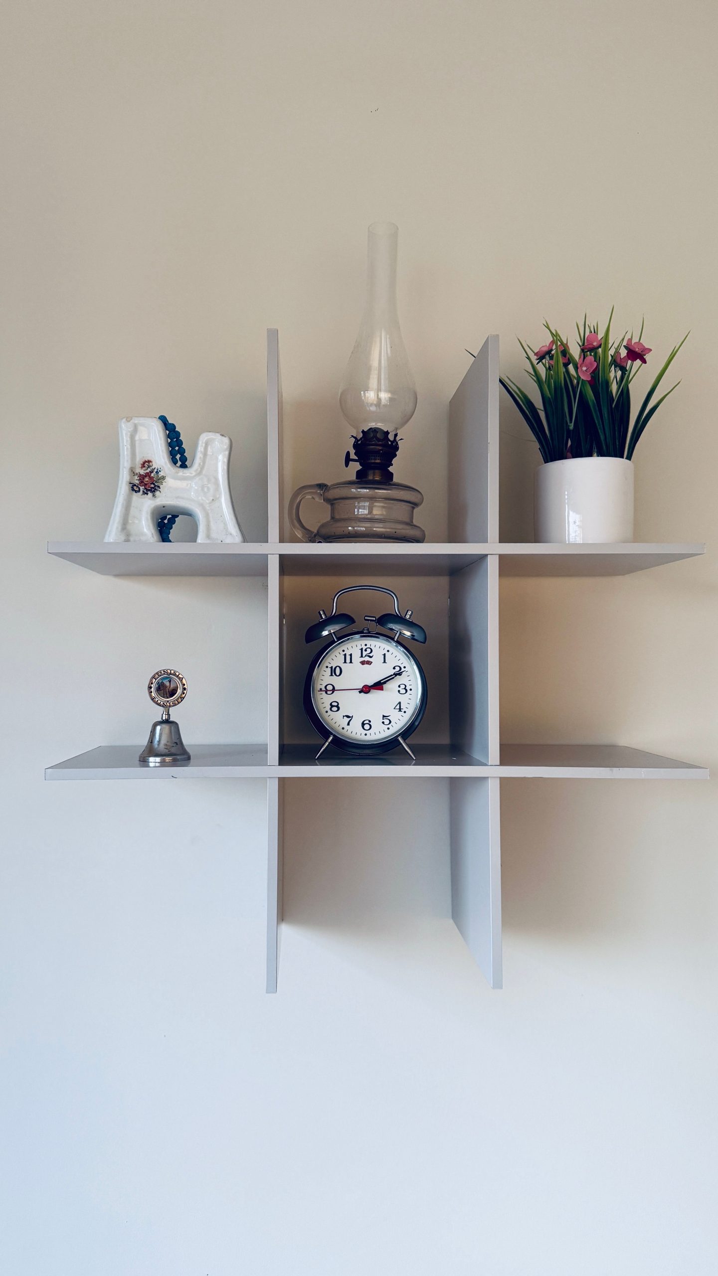 Elegant shelf with vintage clock, plant, and decor pieces, perfect for modern interiors.