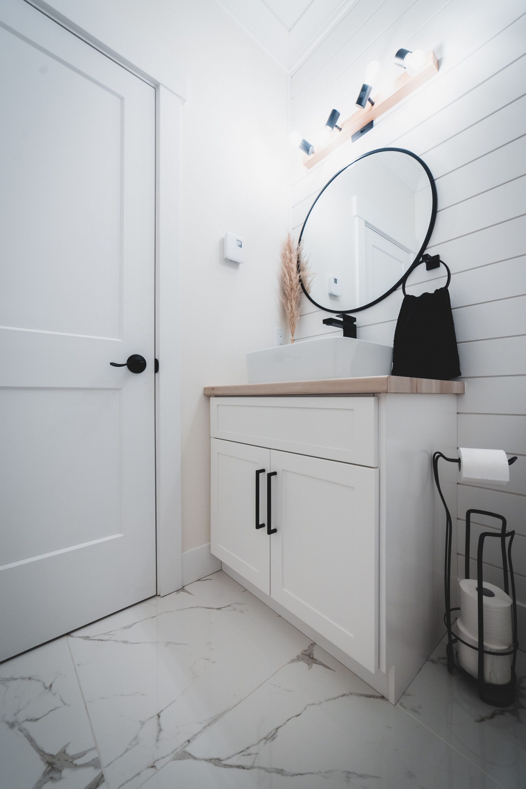 From below of interior of light minimalistic bathroom with white walls furnished with white sink and mirror