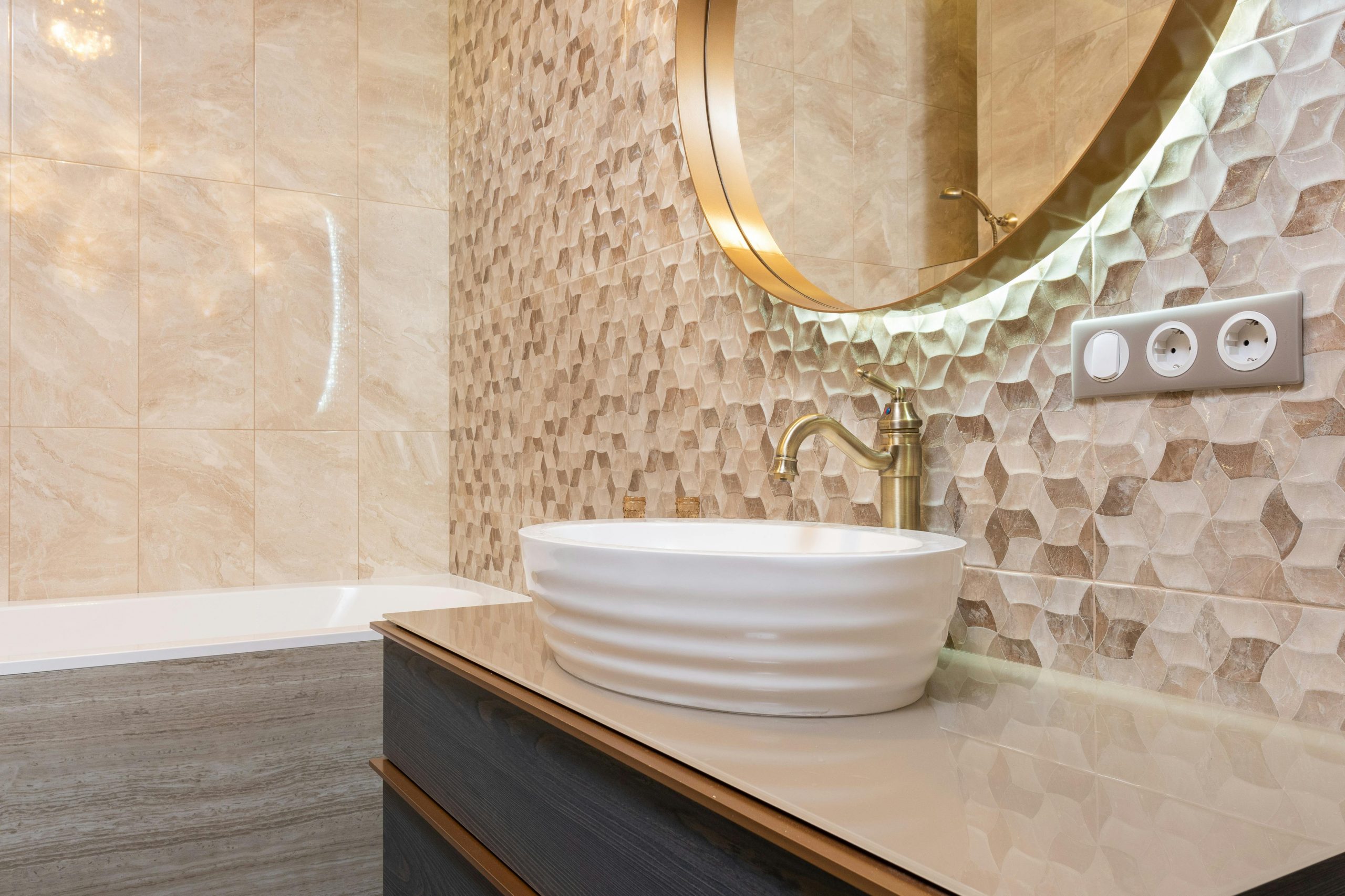 Interior of bright bathroom with sink with tap on cabinet under mirror next to bathtub