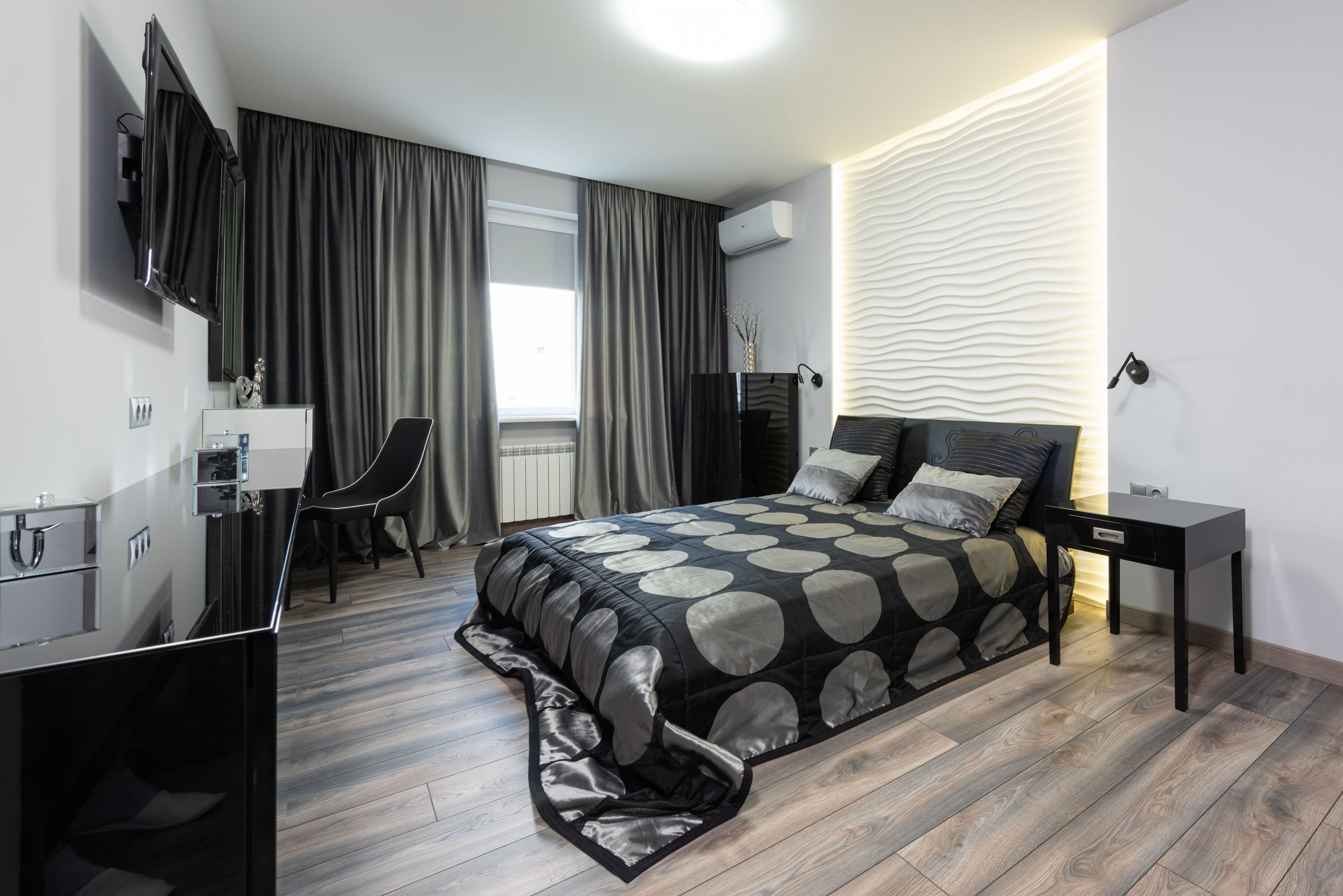 Interior of contemporary hotel bedroom in white and black color with double bed near window