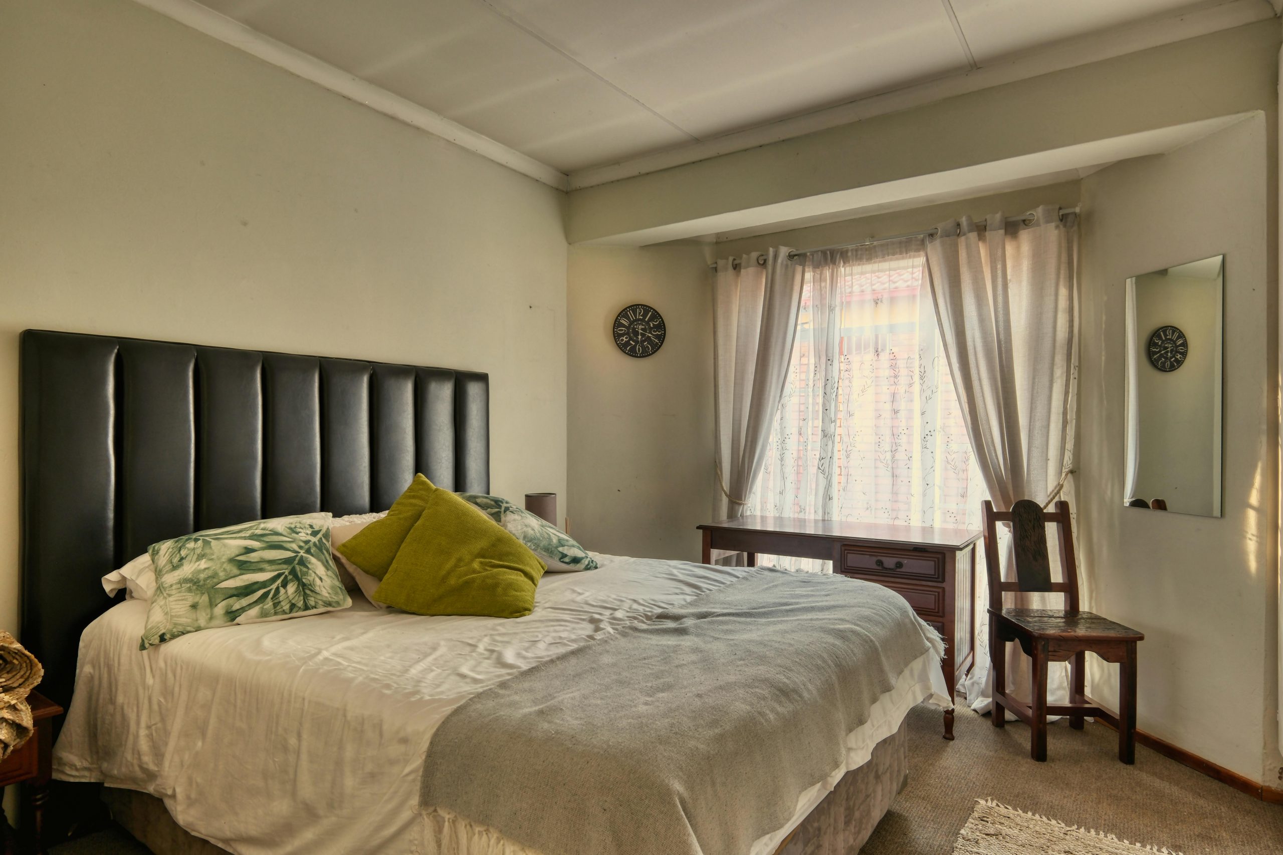 Inviting bedroom featuring a cozy bed, elegant decor, and natural lighting.