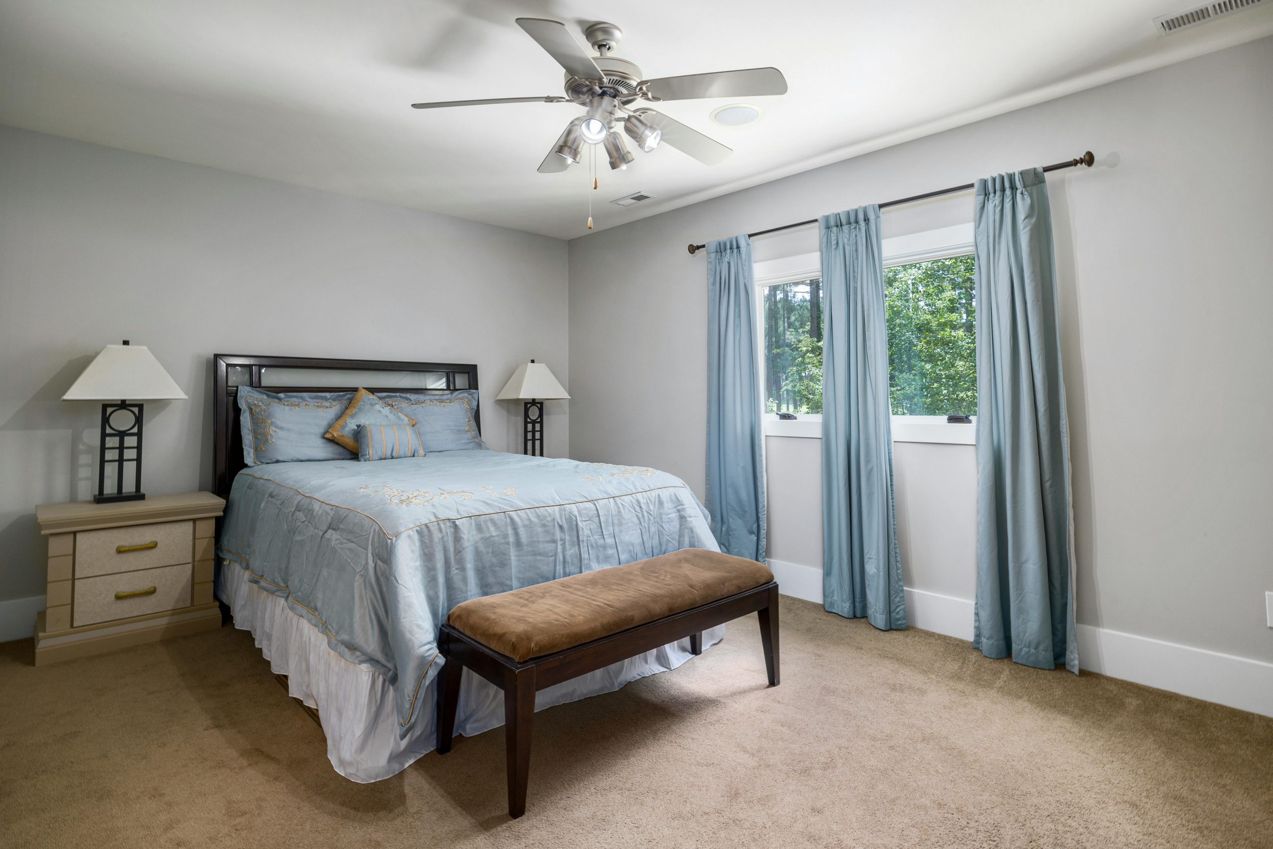 Modern bedroom interior with large bed, natural light, and elegant decor.