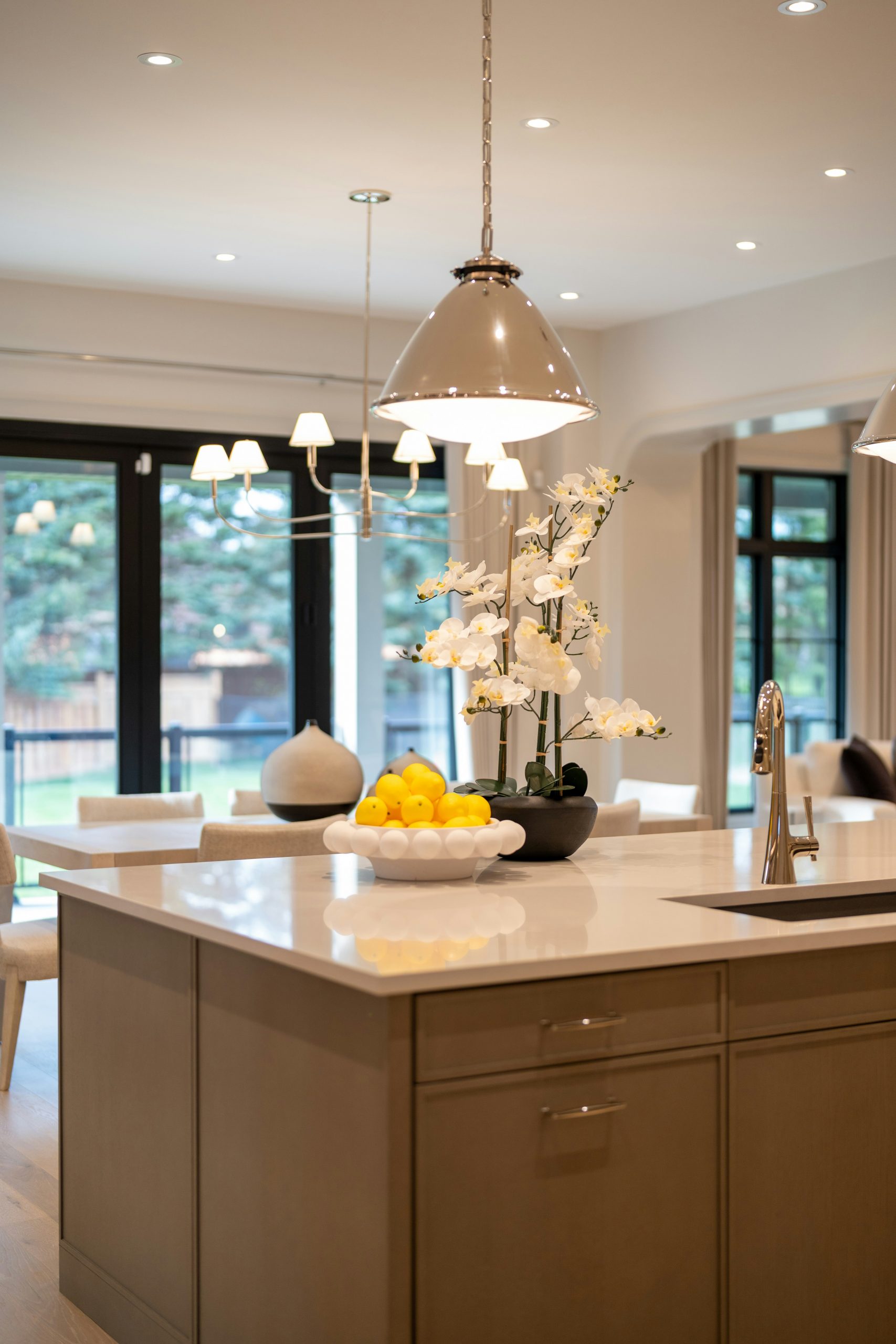 Modern kitchen island with fruit and floral arrangement.