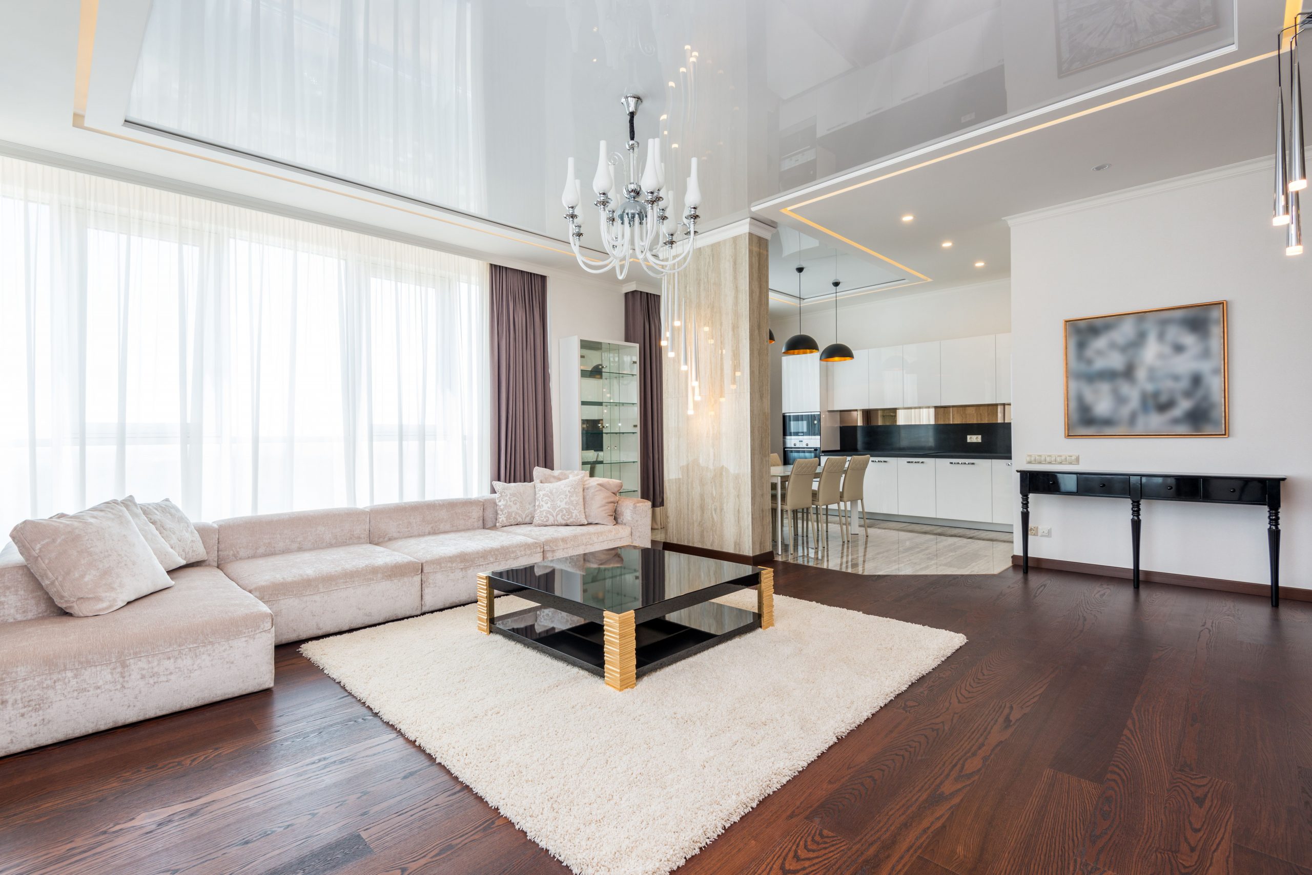 Spacious and elegant modern living room with chandelier and cozy elements.