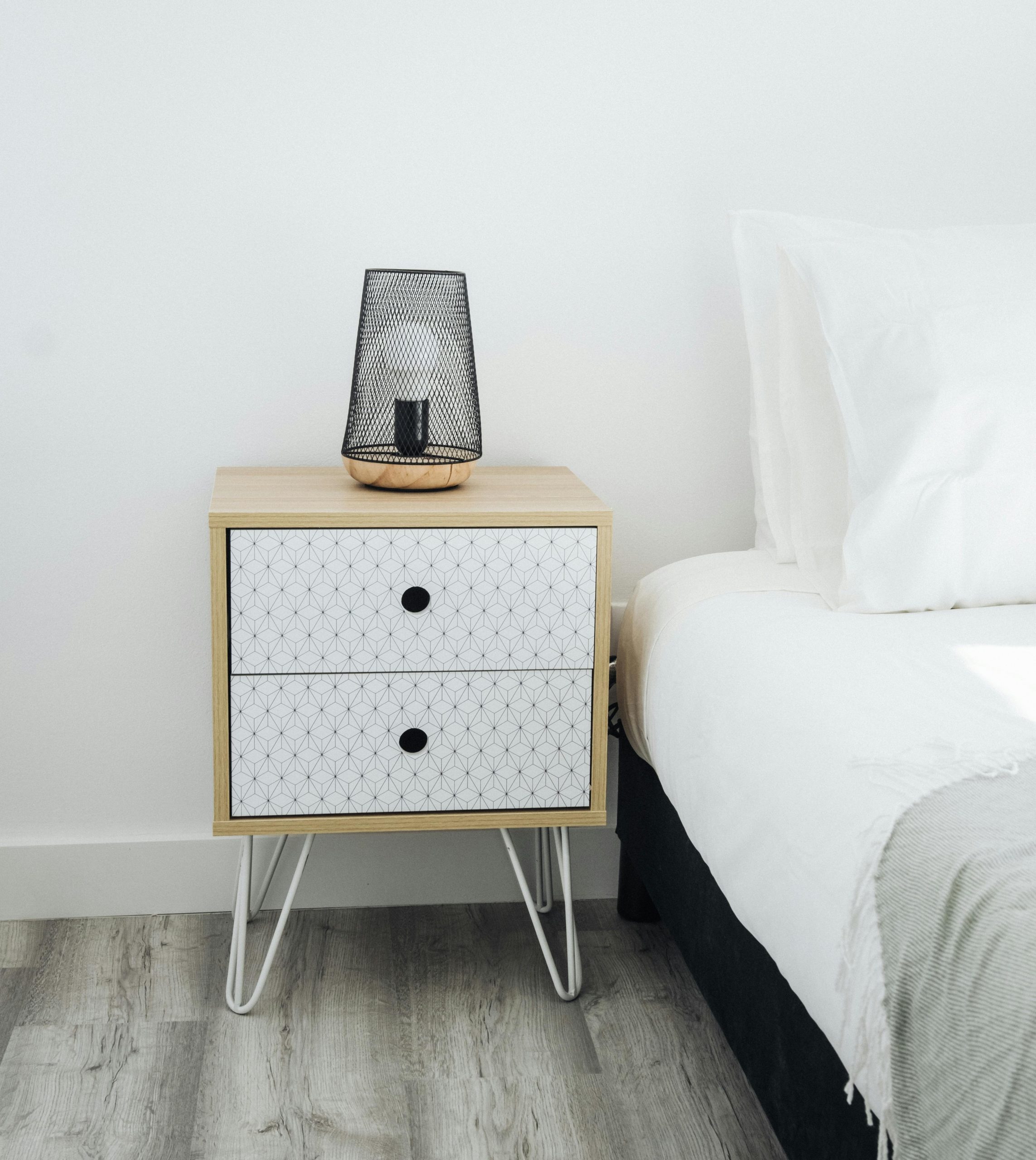 Stylish and modern bedroom featuring a minimalist nightstand with a decorative lamp.