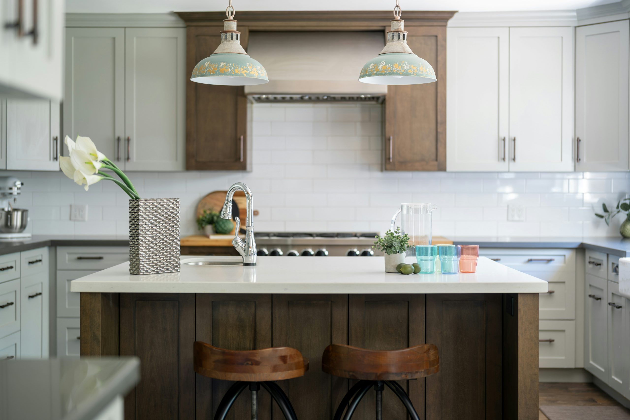 Stylish kitchen featuring an island, bar stools, and pendant lights.
