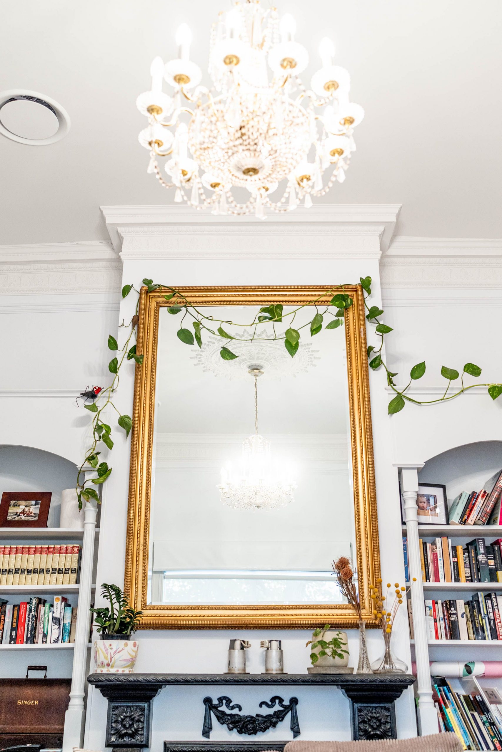 Stylish living room featuring a large ornate mirror and elegant chandelier, emanating luxury and sophistication.