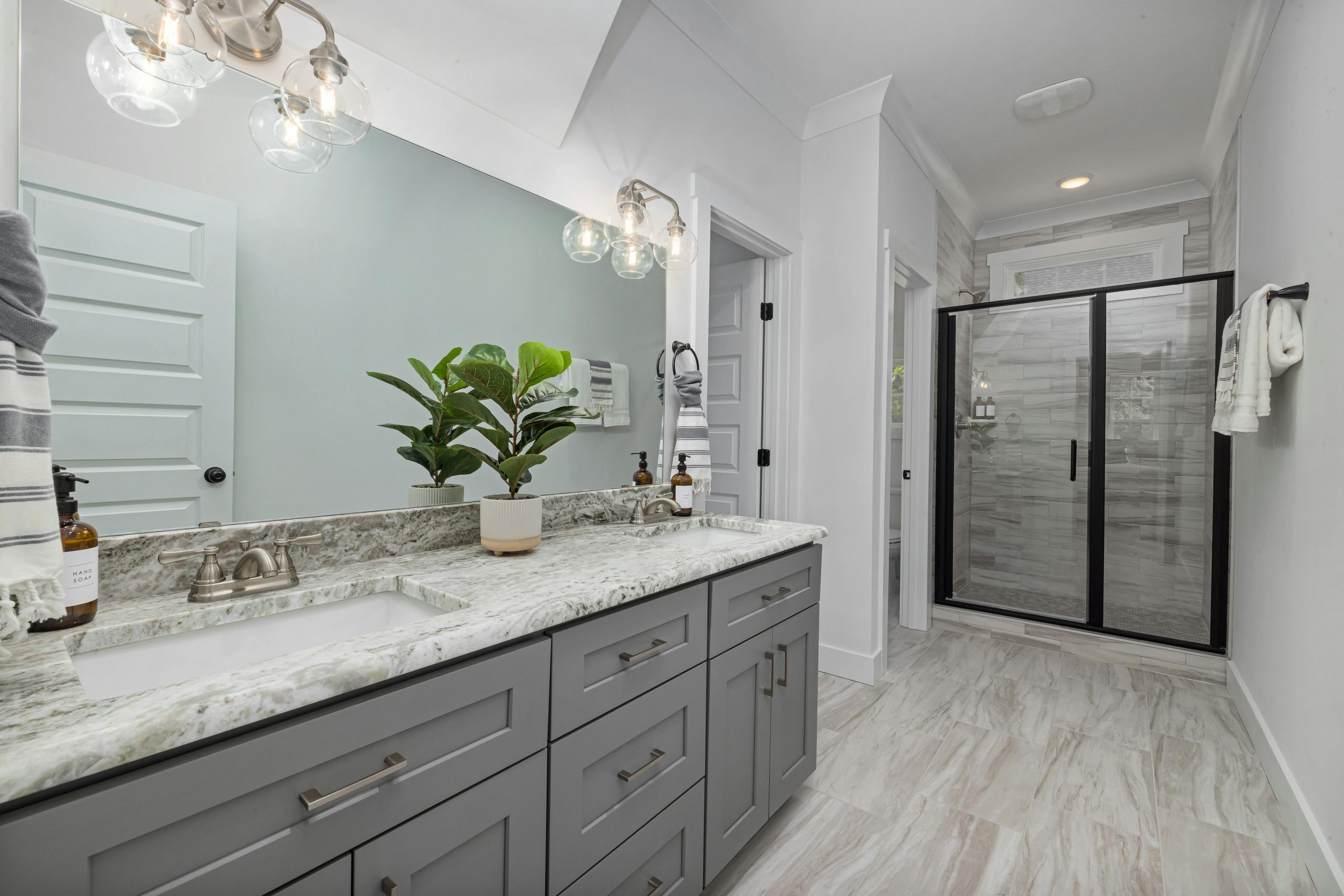 Stylish modern bathroom with minimalist design featuring a large mirror and elegant fixtures.
