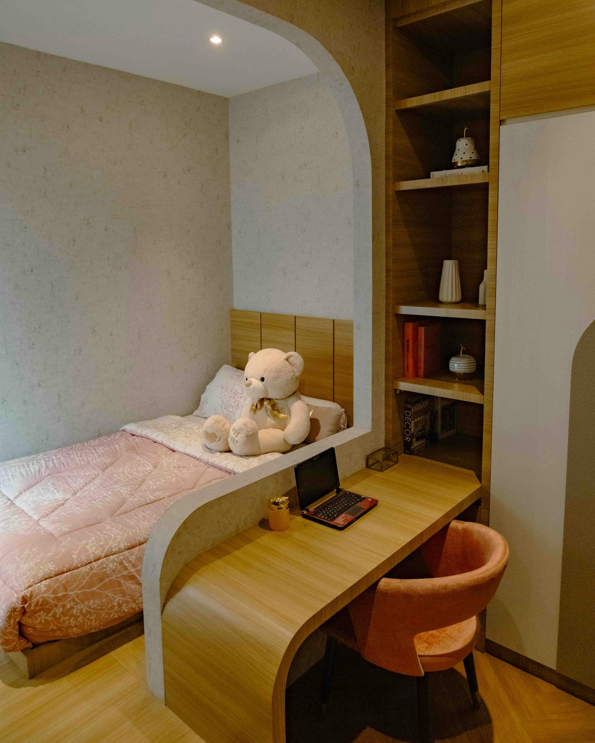 Warm and inviting bedroom design with integrated workspace, ideal for relaxation in Jakarta.
