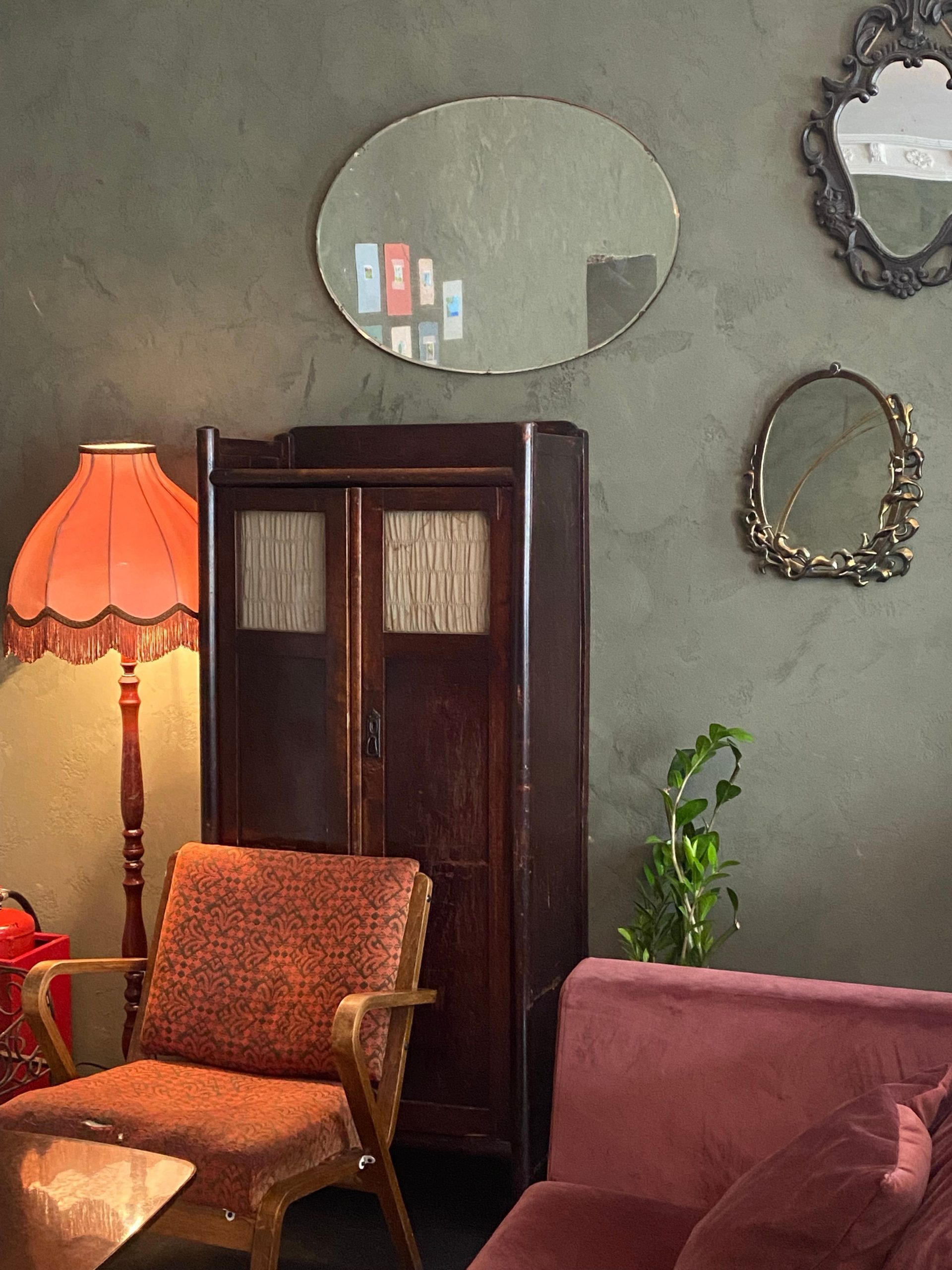 Warm and inviting vintage living room featuring retro furniture, ornate mirrors, and classic lighting for a nostalgic ambiance.
