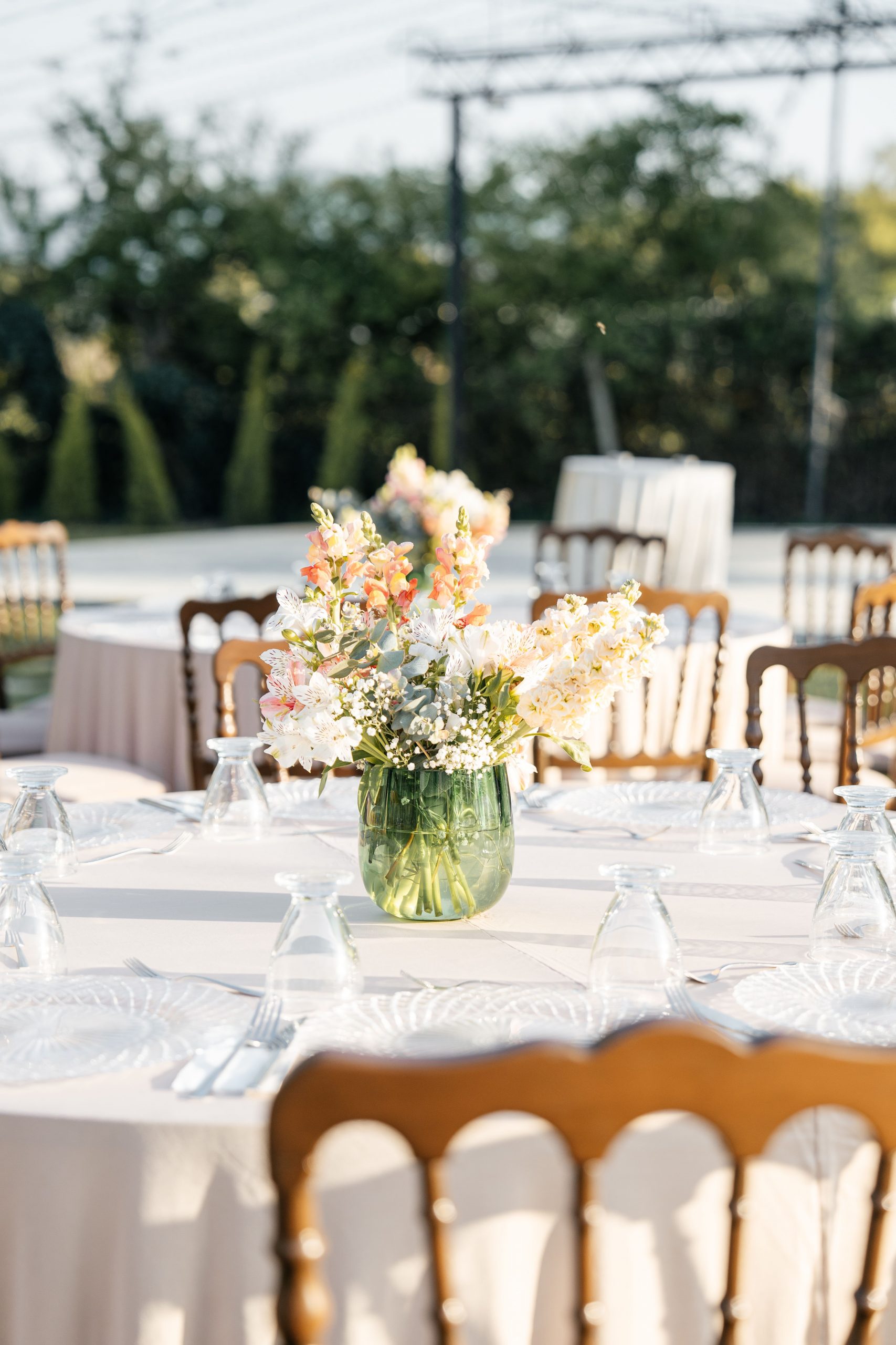 A beautifully arranged outdoor wedding table with elegant floral centerpiece.