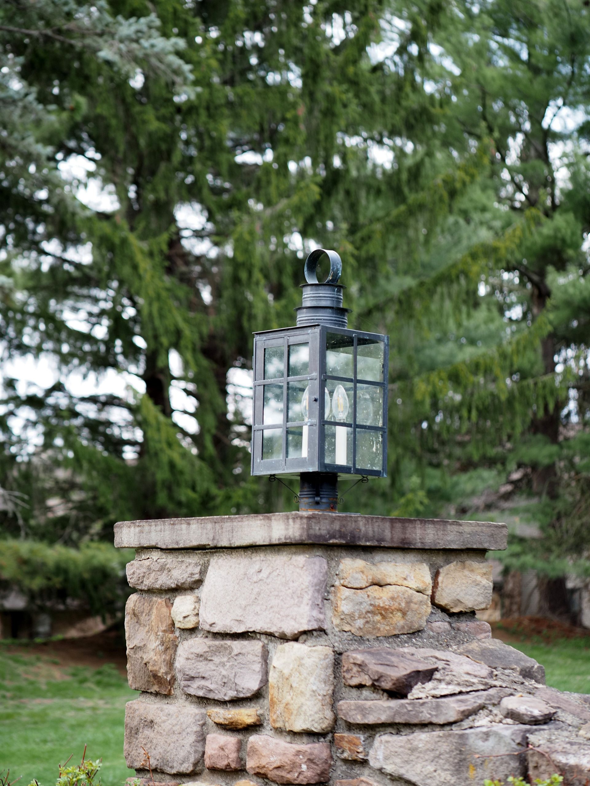 A charming stone lantern mounted on a garden wall in Warrington, showcasing rustic outdoor decor.
