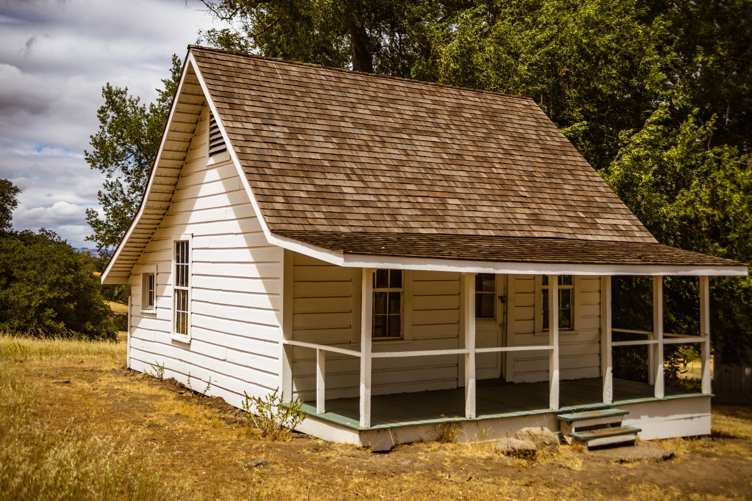A quaint rustic wooden bungalow with a classic design amidst nature, evoking a nostalgic charm.