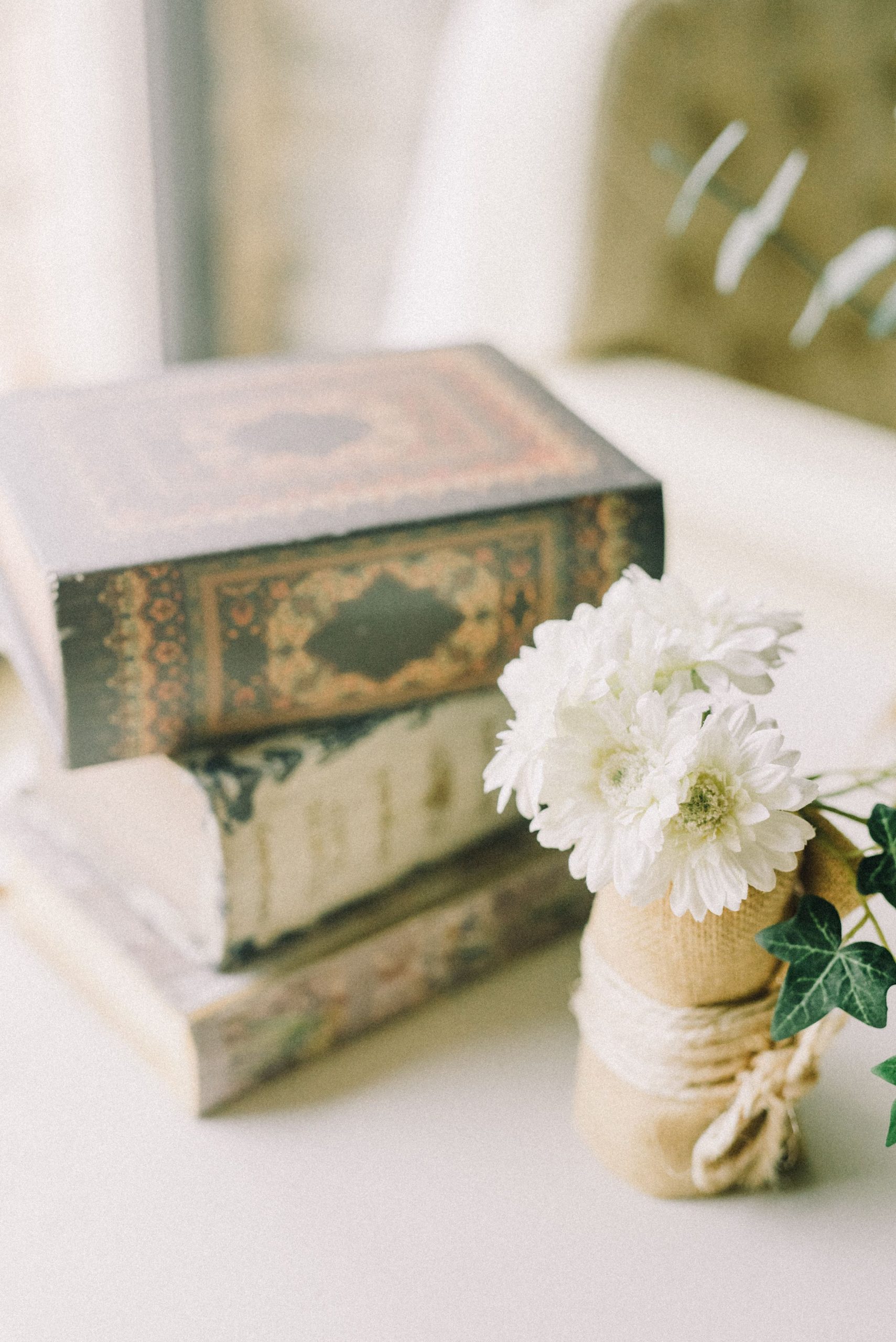 A serene setup featuring vintage books and fresh white flowers for decorative indoor elegance.