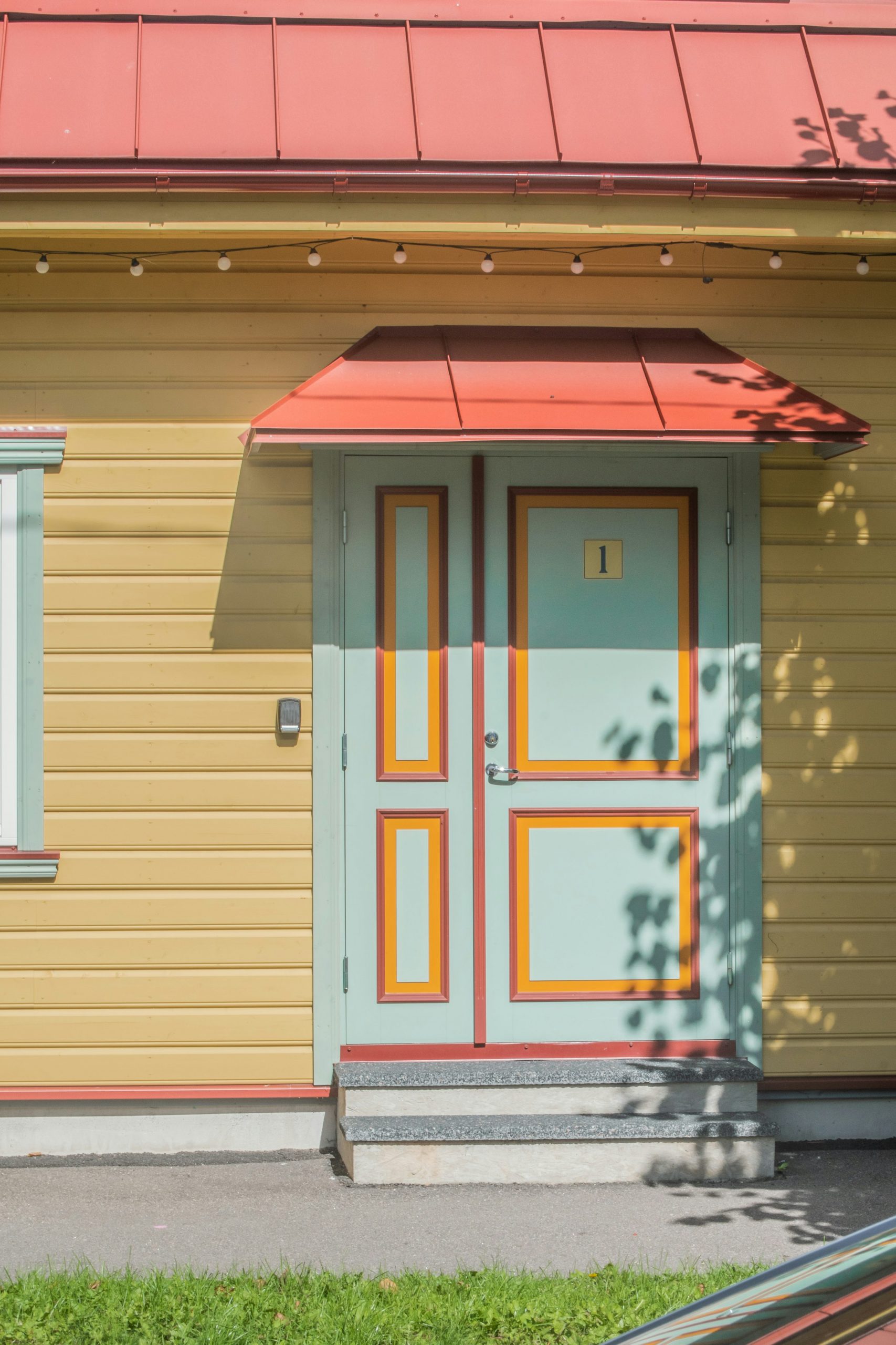 A yellow house with a red roof and a blue door photo – Free House Image on Unsplash