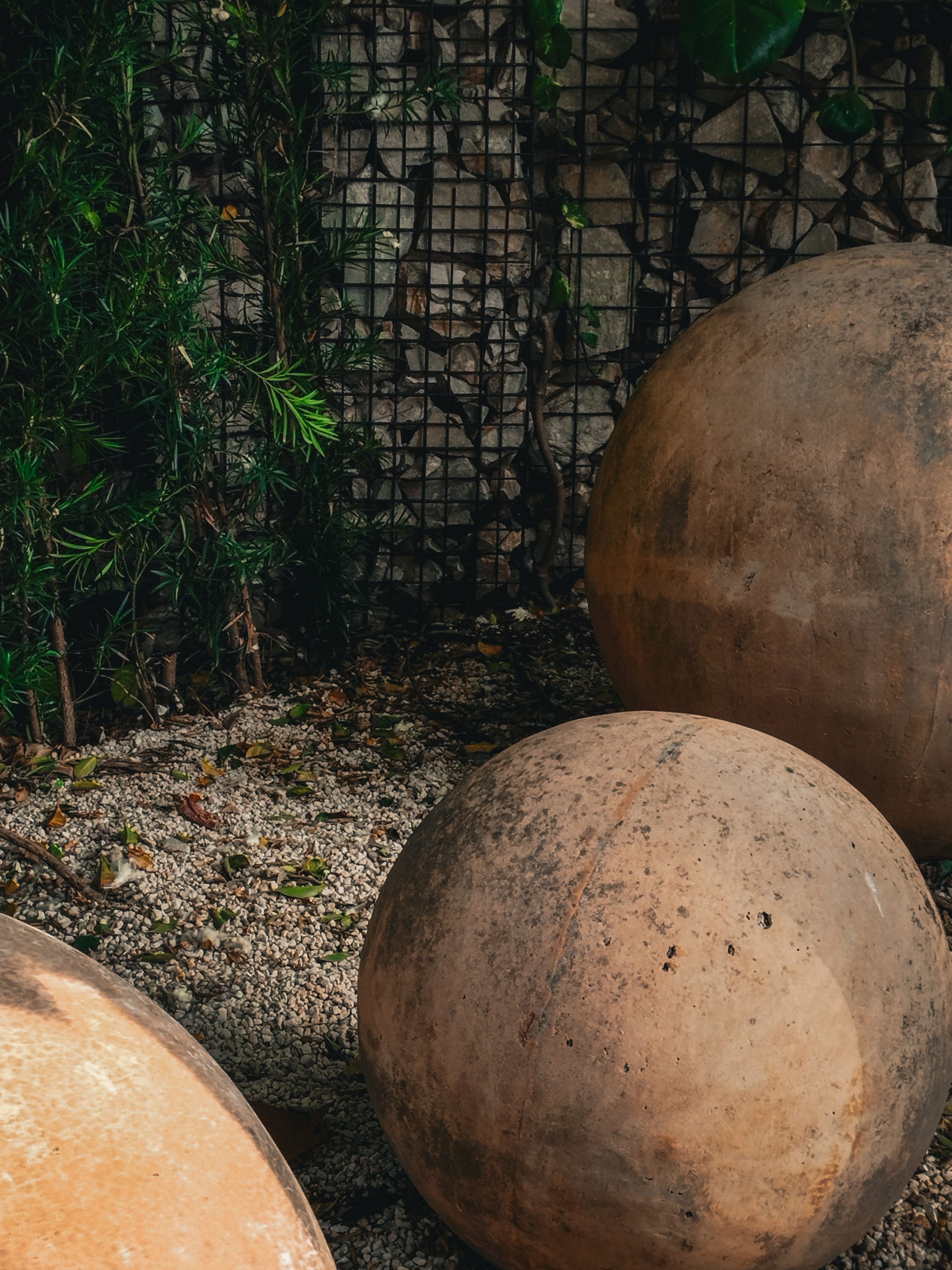 Artistic stone spheres in an outdoor Brazilian garden setting.