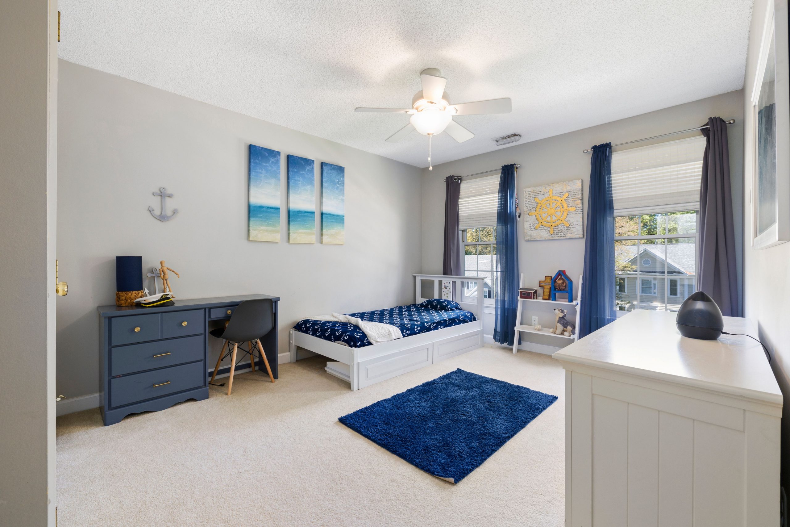 Bright and spacious child's bedroom with nautical decor and natural lighting.